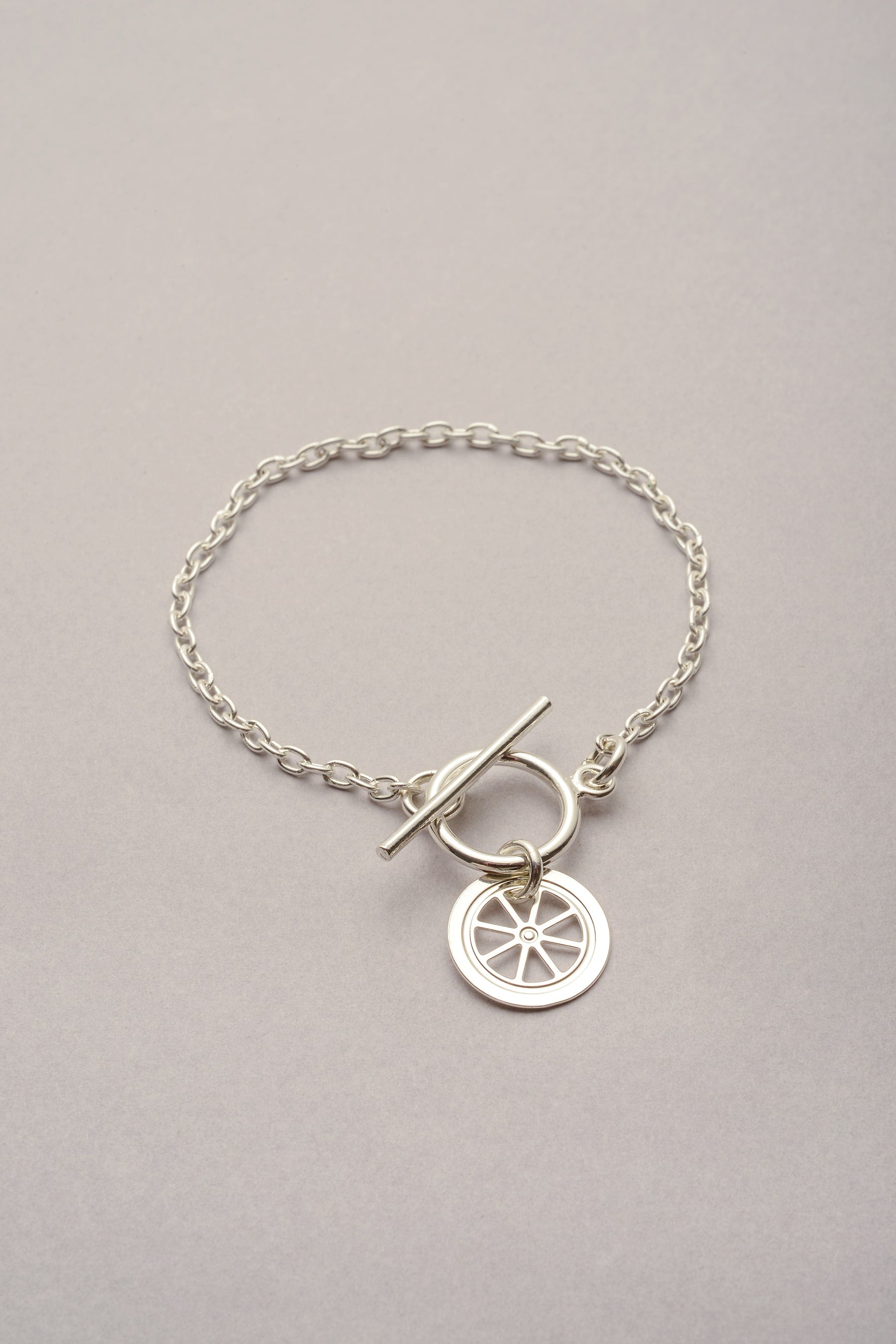 Ce bracelet est composé d'un chaîne, d'un fermoir en T et d'un pendentif roue évidé. Bijou argenté pour femme inspiré du triporteur bijoux à Toulouse. 