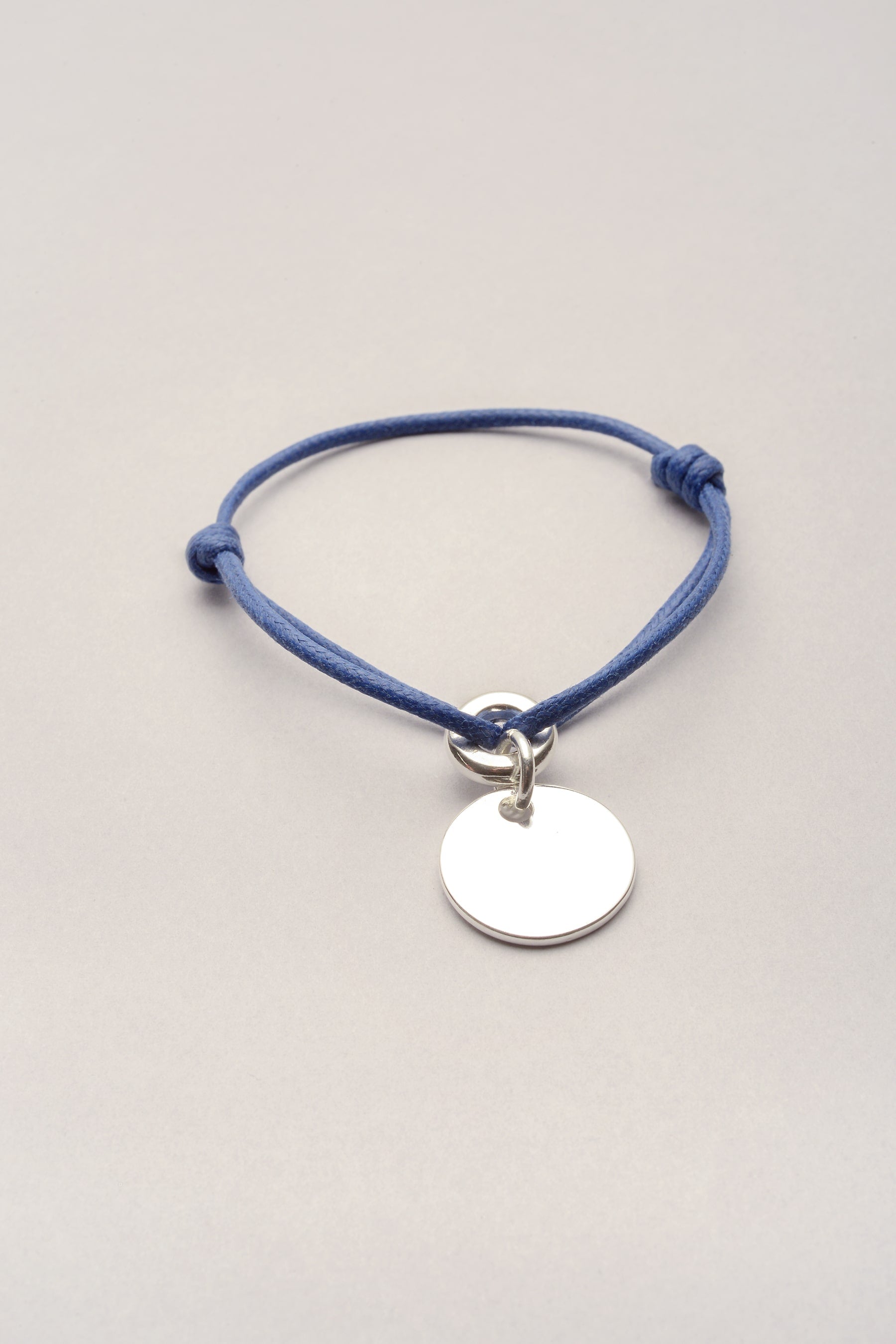 Ce bracelet est composé d'une Médaille avec cordon de coton colore réglable. Bijou fantaisie fabriqué en France, idéal en premier bijou. 