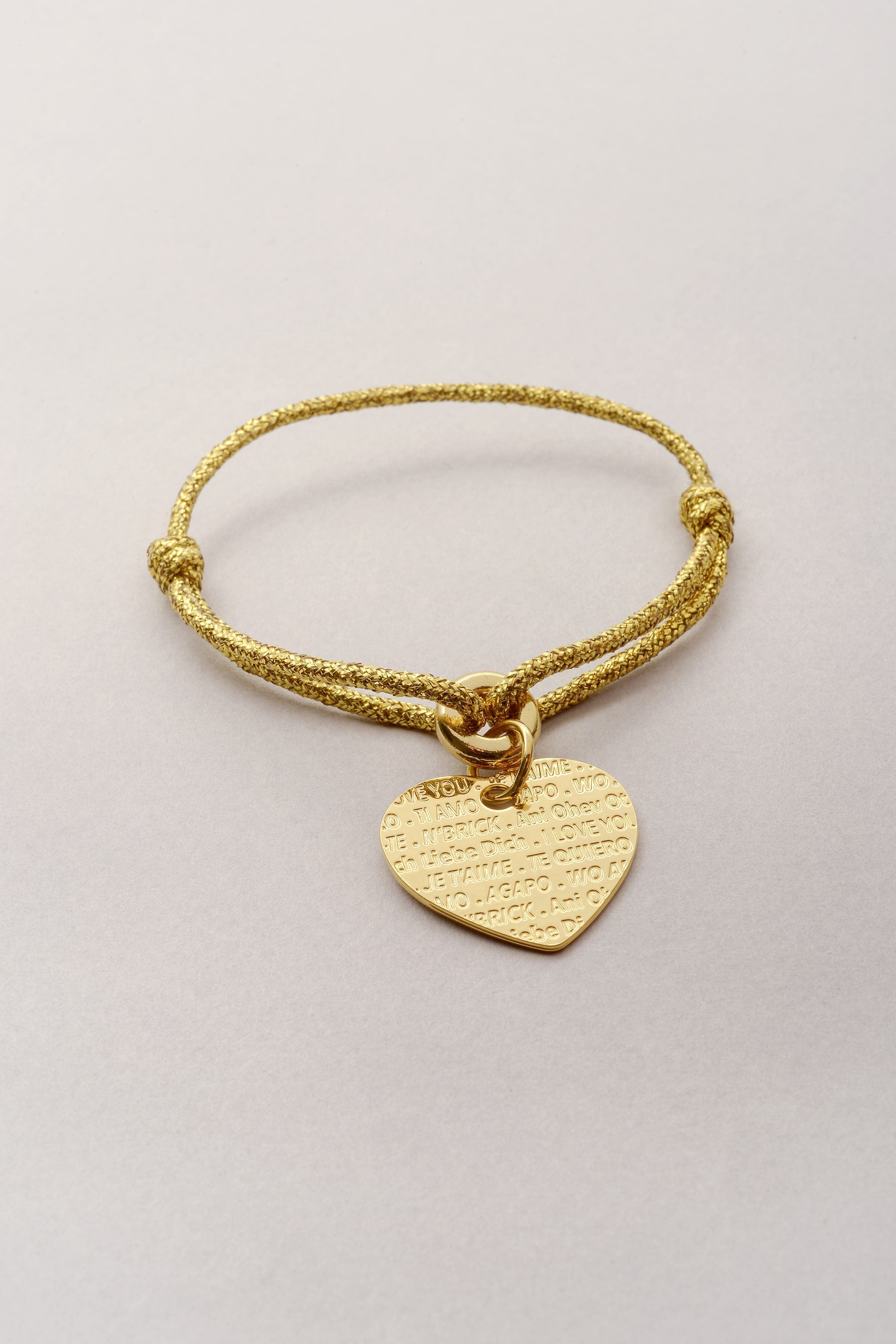 Ce bijou est composé d'un cordon réglable et d'un pendentif coeur. Sur le pendentif coeur, est inscrit la phrase "je t'aime'" en plusieurs langues. Création Musardise fabriquée en France. 
