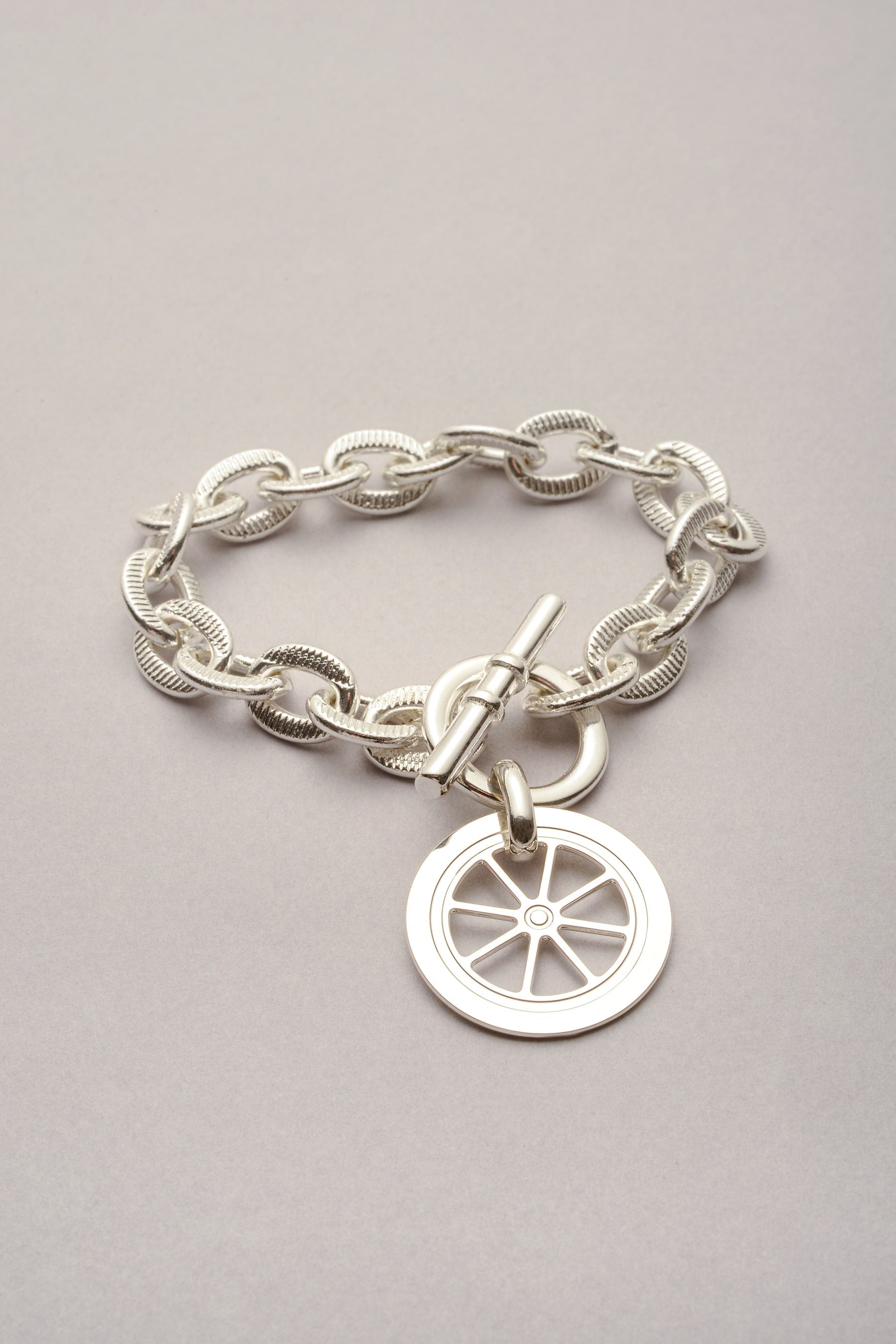 Le bracelet Scarlett pendentif Roue est composé d'une chaîne argenté et d'un fermoir en T. Bijou fabriqué en France. 