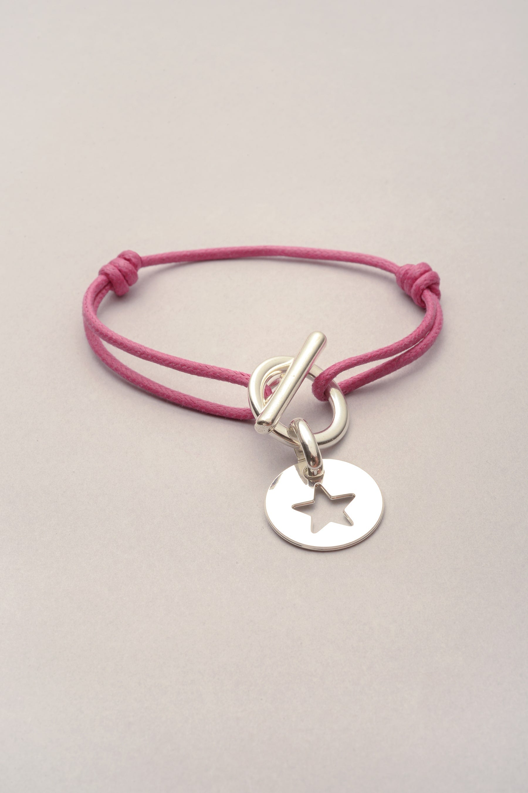 Ce bracelet attache médaille étoile avec cordon de coton coloré est ajustable. 
