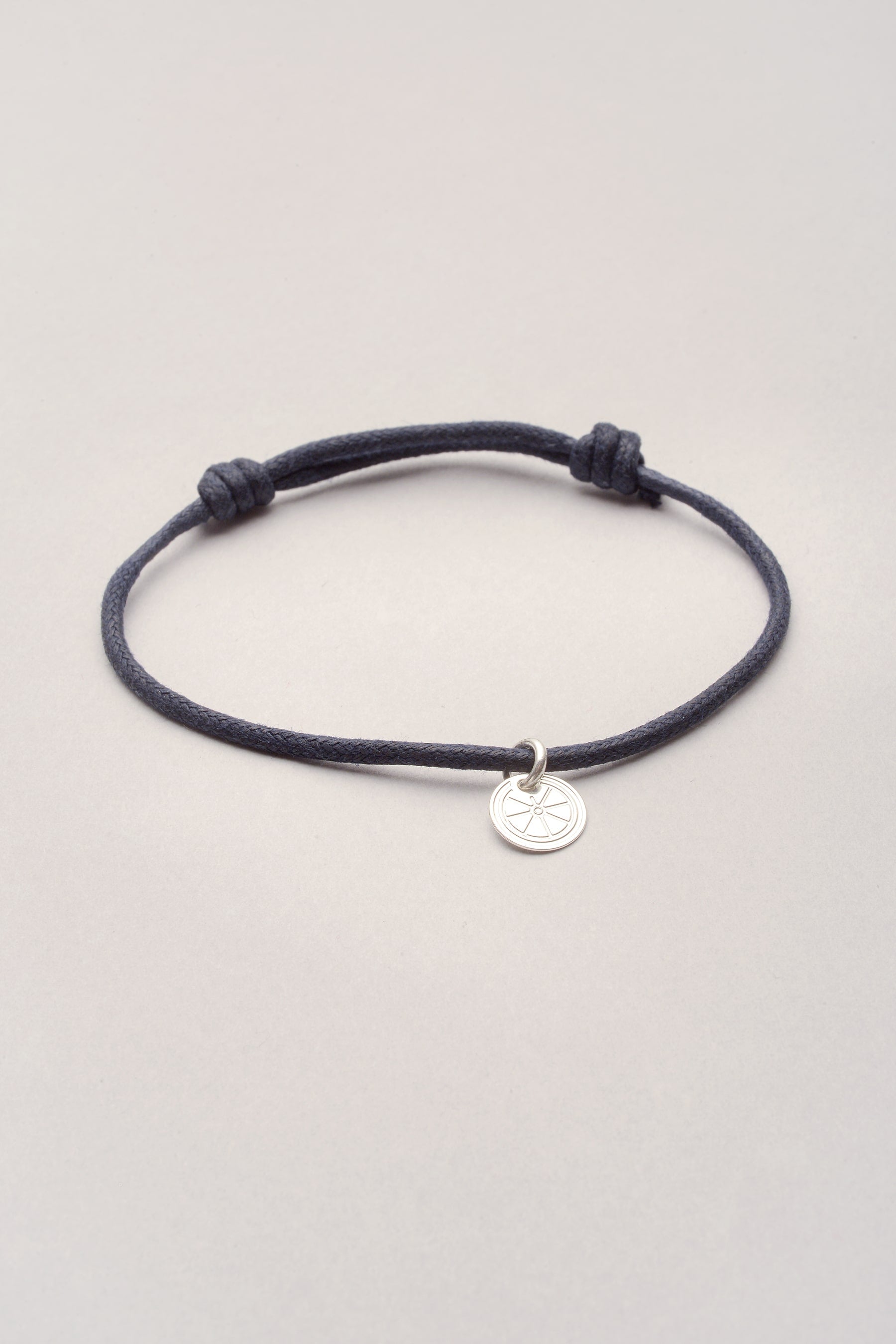 Bracelet cordon avec petite médaille roue Musardise. Ce bracelet est ajustable et coloré, et vous pouvez ajouter dessus vos pendentifs personnels ! 