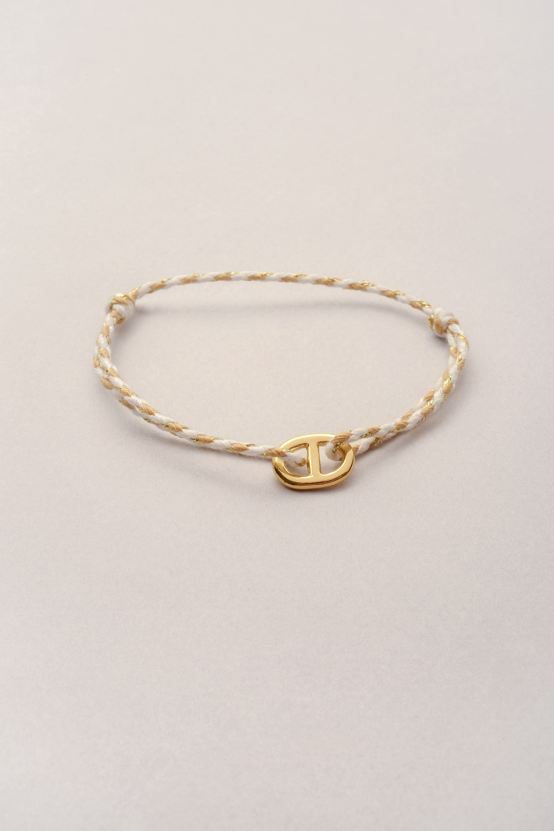 Le bracelet cordon tressé de Musardise avec sa breloque maille marine dorée