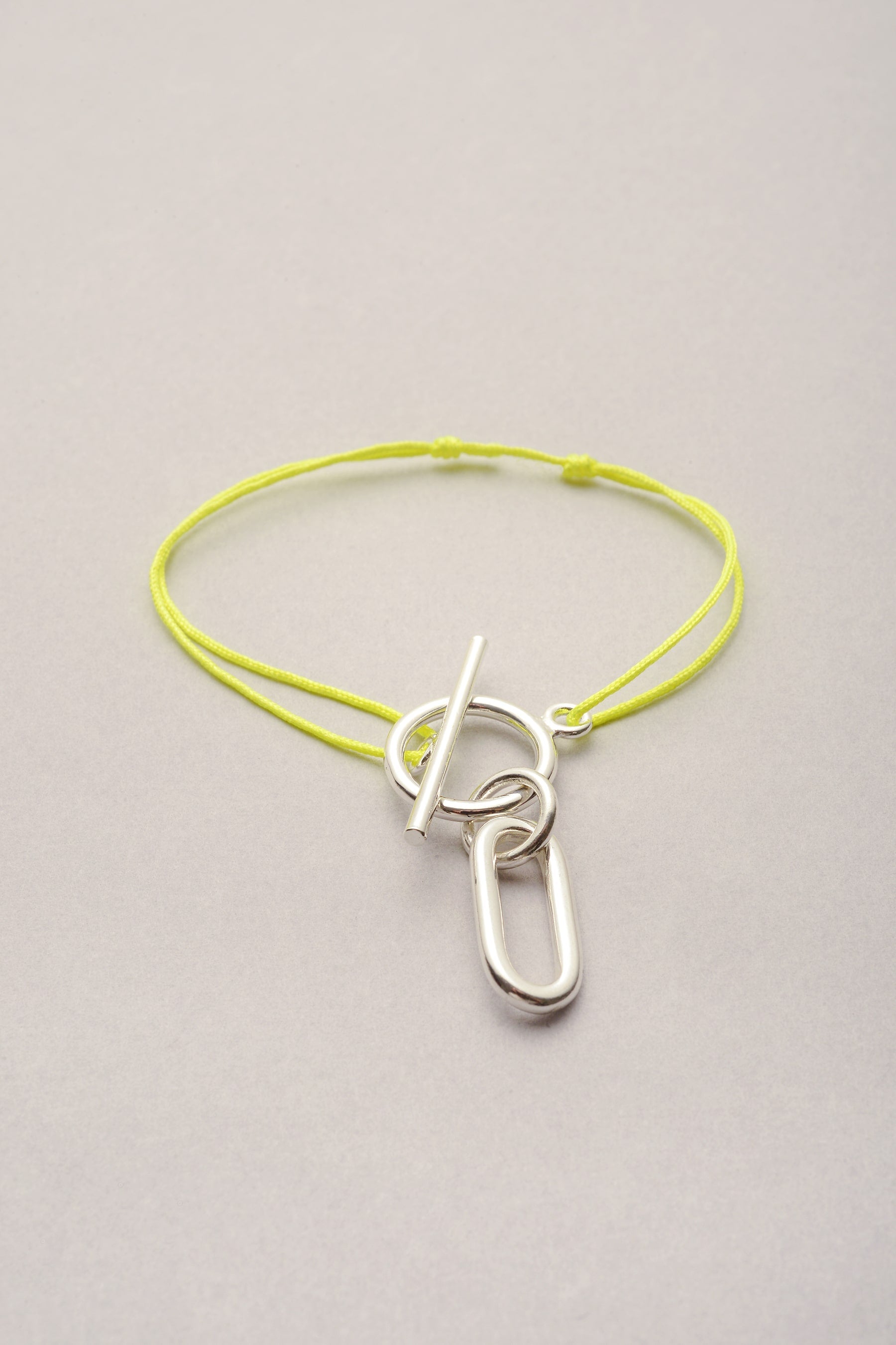 Le bracelet Lou argenté sur cordon fin coloré avec sa breloque argentée en forme ovale Ricky