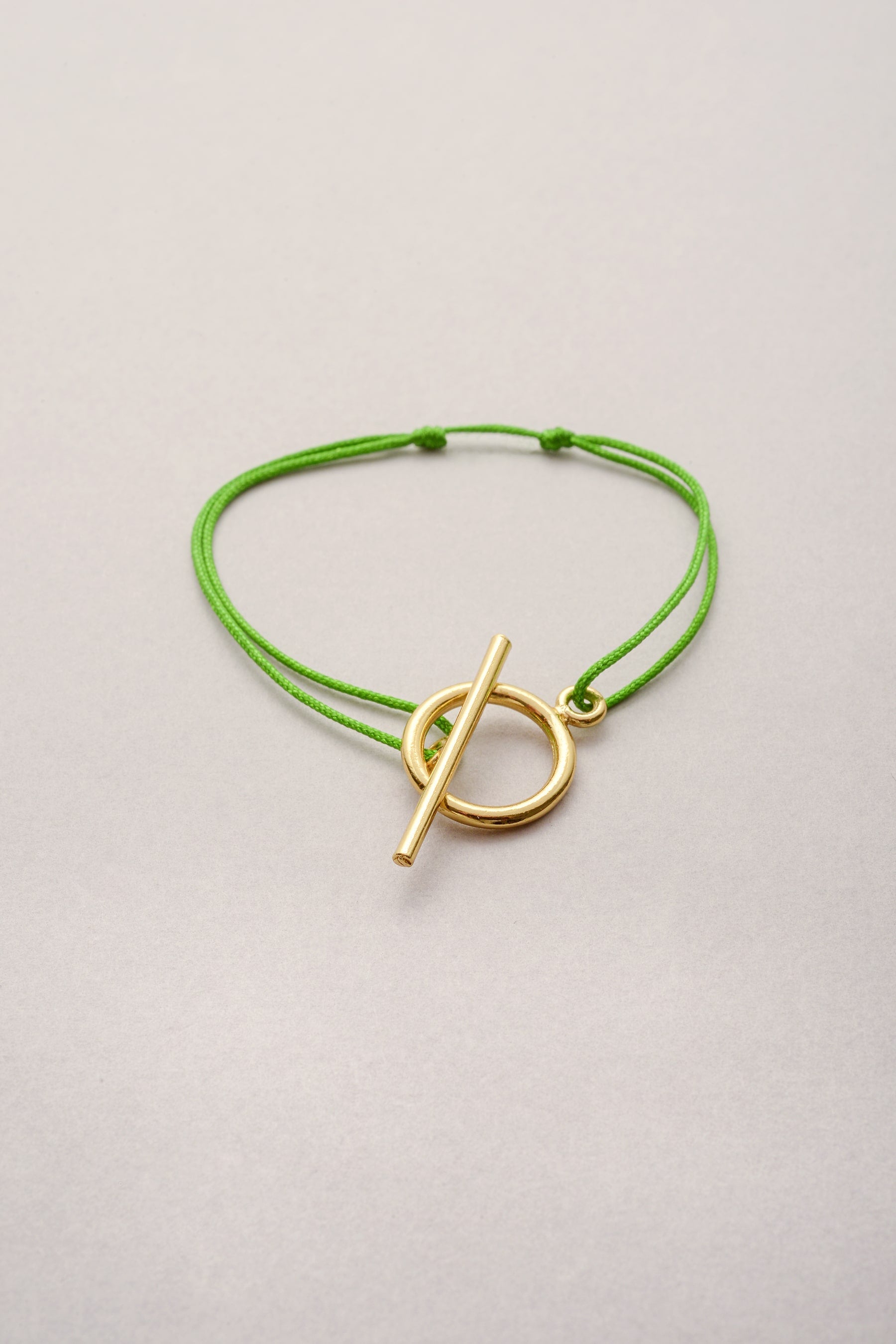 Le bracelet Lou doré simple de Musardise sur cordon fil fin coloré. fermoir en T simple sans pendentif