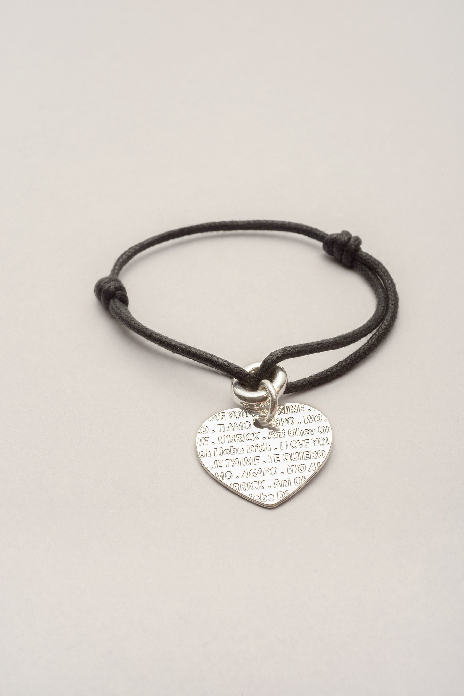 Ce bracelet est composé d'un cordon réglable et d'un pendentif coeur avec des inscriptions je t'aime gravées. Inspiré du mur des je t'aime à Paris, ce bracelet est une idée de cadeau amoureux, saint Valentin noel... 
