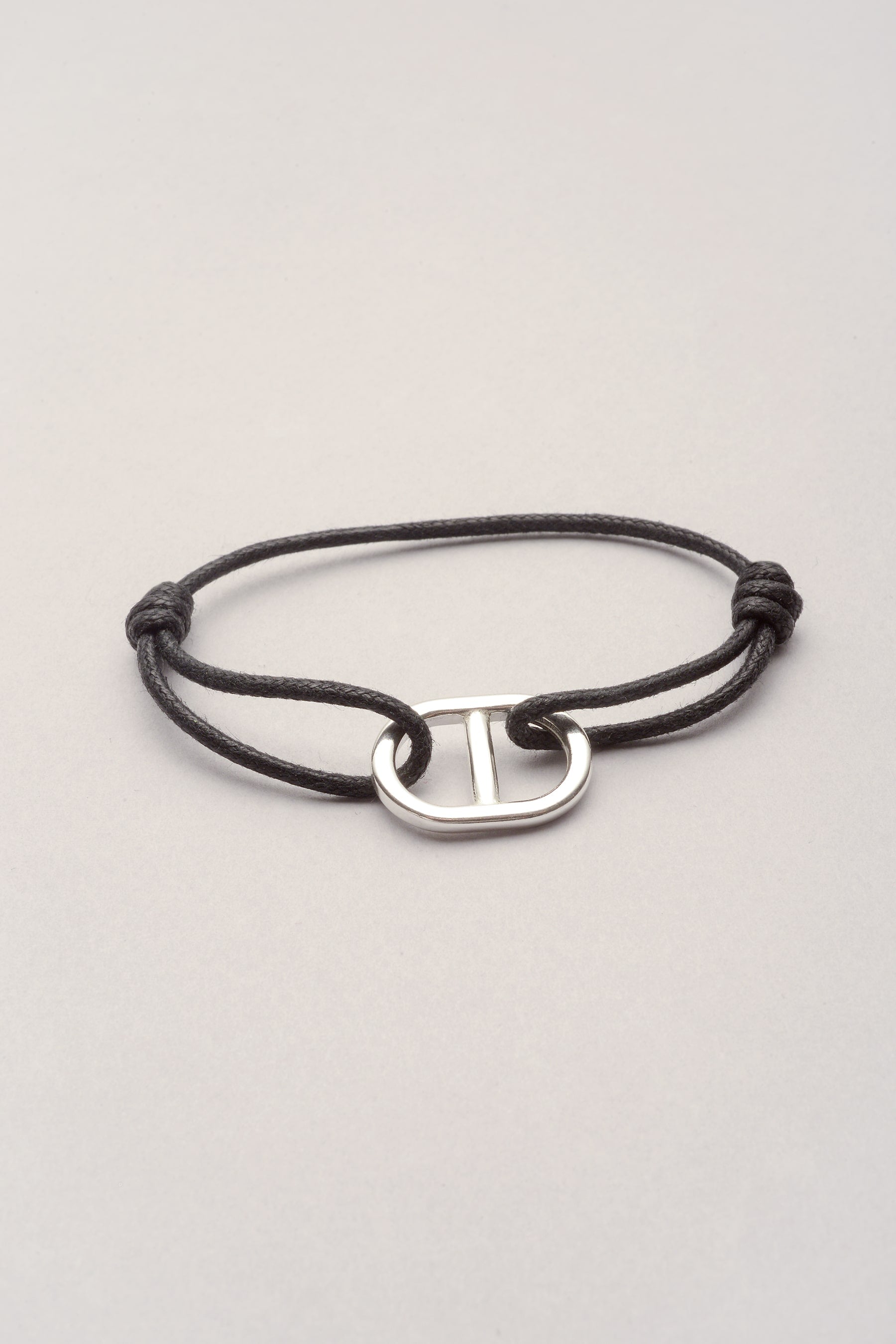 Ce bracelet est composé d'un pendentif maille marine argenté et d'un cordon de coton coloré. Ajustable, ce bijou s'adapte au poignet grâce à ses deux noeuds coulissants. Mixte, il est idéal en bijou de couple. 