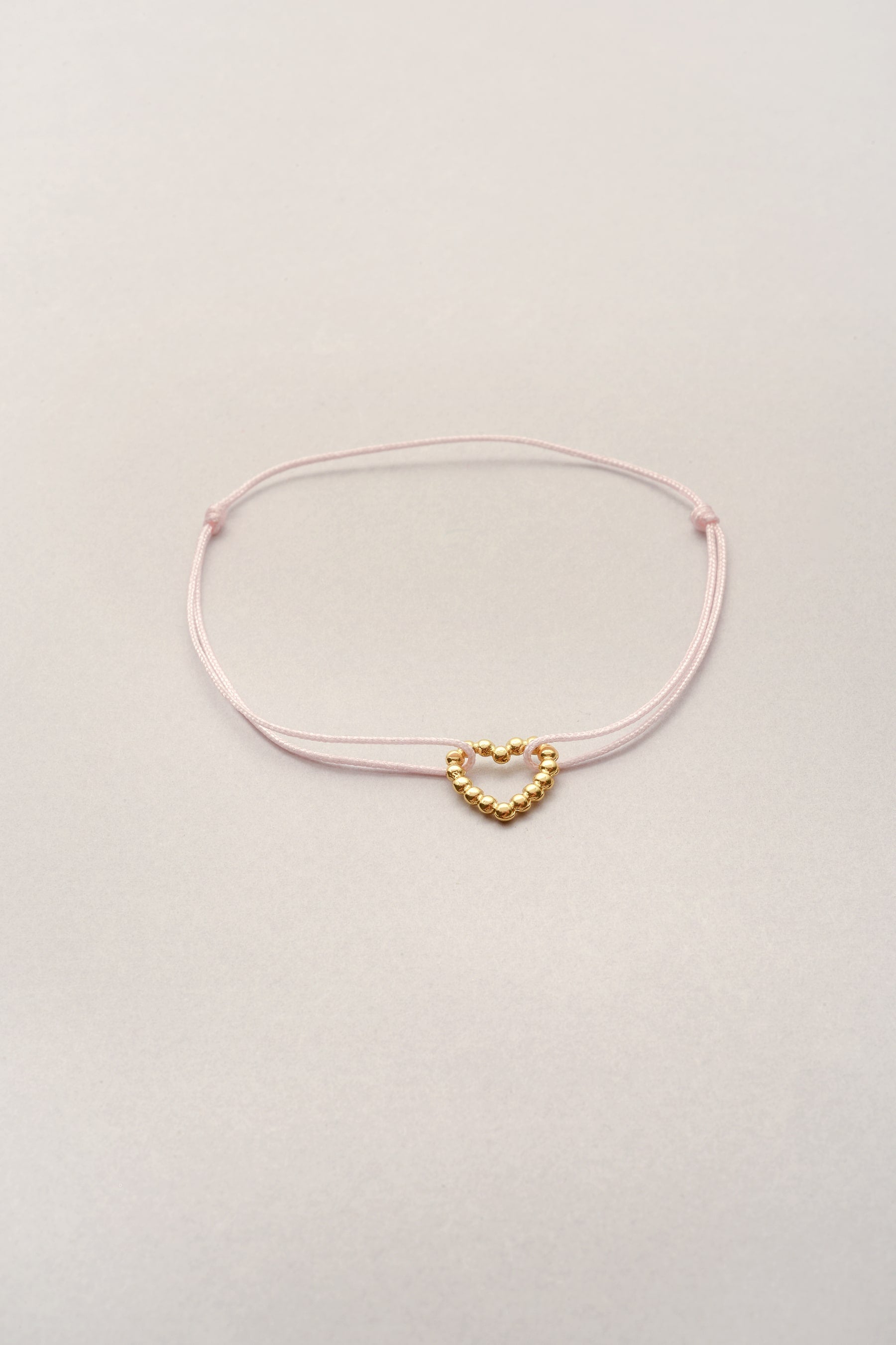 Bracelet petit cœur doré Musardise, bijou fantaisie français sur cordon fin coloré personnalisable avec pendentif cœur doré à l’or fin, assemblé à la main à Toulouse.