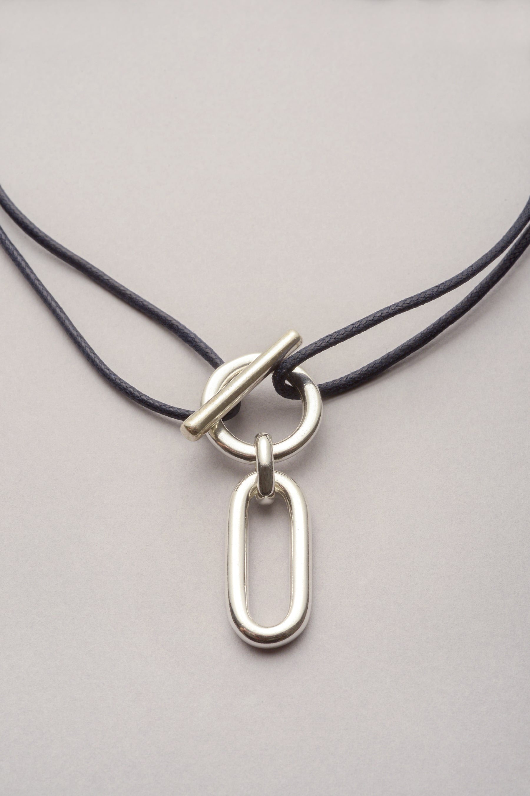 Ce bijou est composé d'un cordon reglable et d'une attache avec un pendentif oval "Ricky". L'attache est un fermoir en T, qui permet de mettre et enlever facilement le collier au quotidien. 