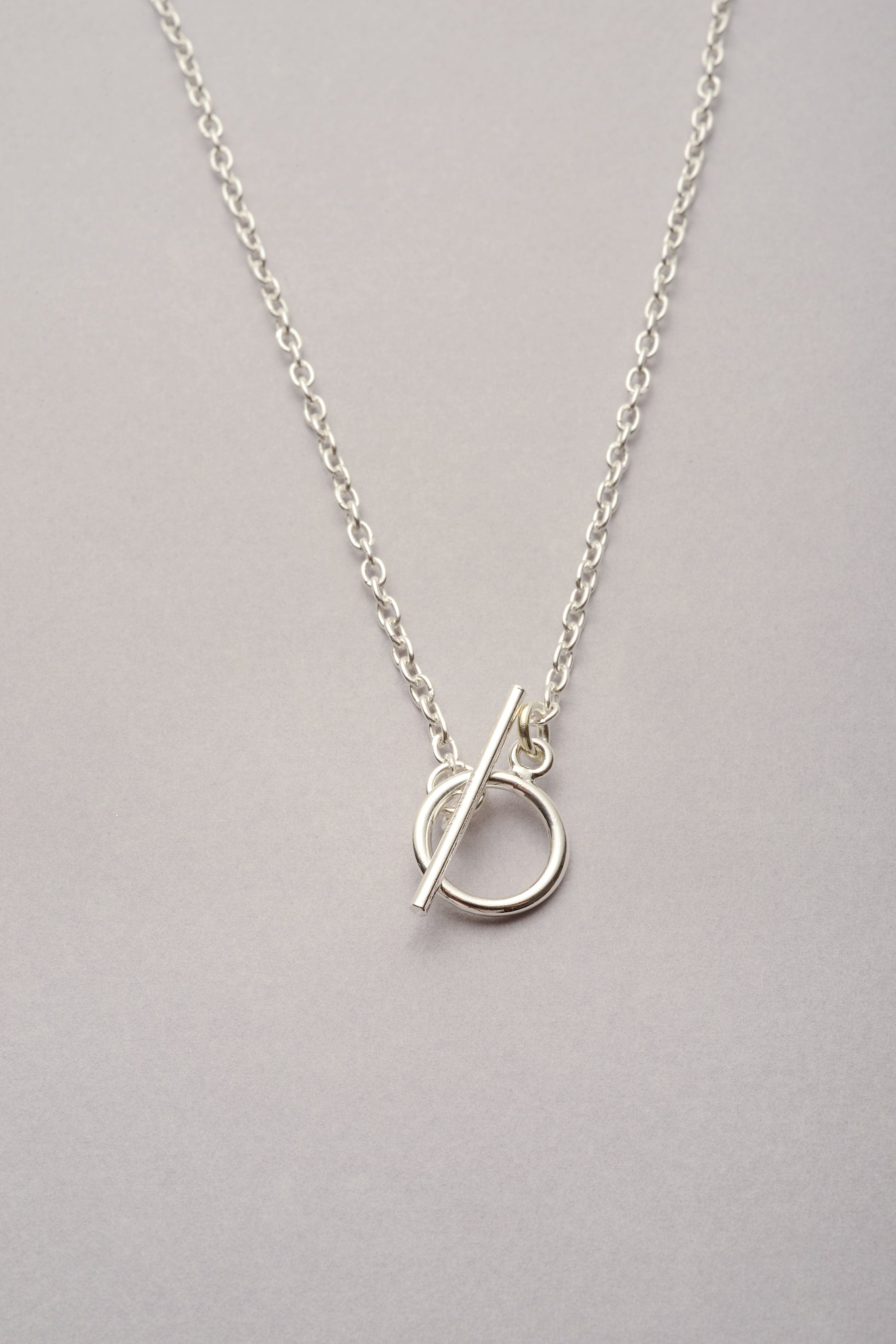 Collier argenté avec chaîne fine argentée montée sur un fermoir en T. Ce bijou fabriqué en France est pour homme et femme. 