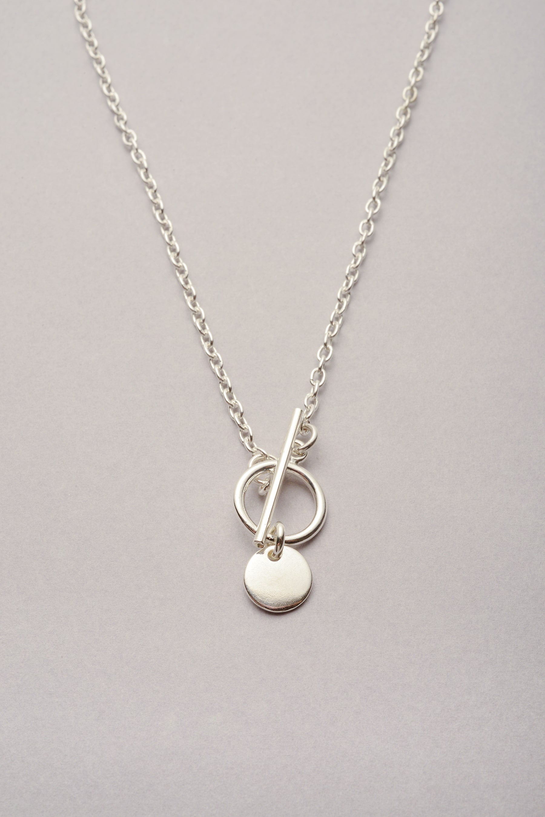 Collier chaîne fine médaille argenté "Lou" avec un fermoir un T. Ce bijou fantaisie pour femme est fabriqué en France à prix doux. 