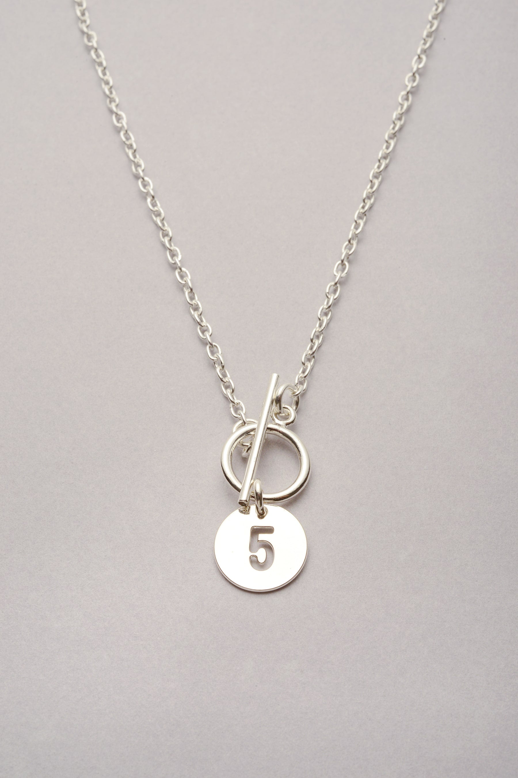 Le collier chaîne fine médaille chiffre argenté "Lou" est fabriqué en France. Bijou personnalisable avec un chiffre évidé. 