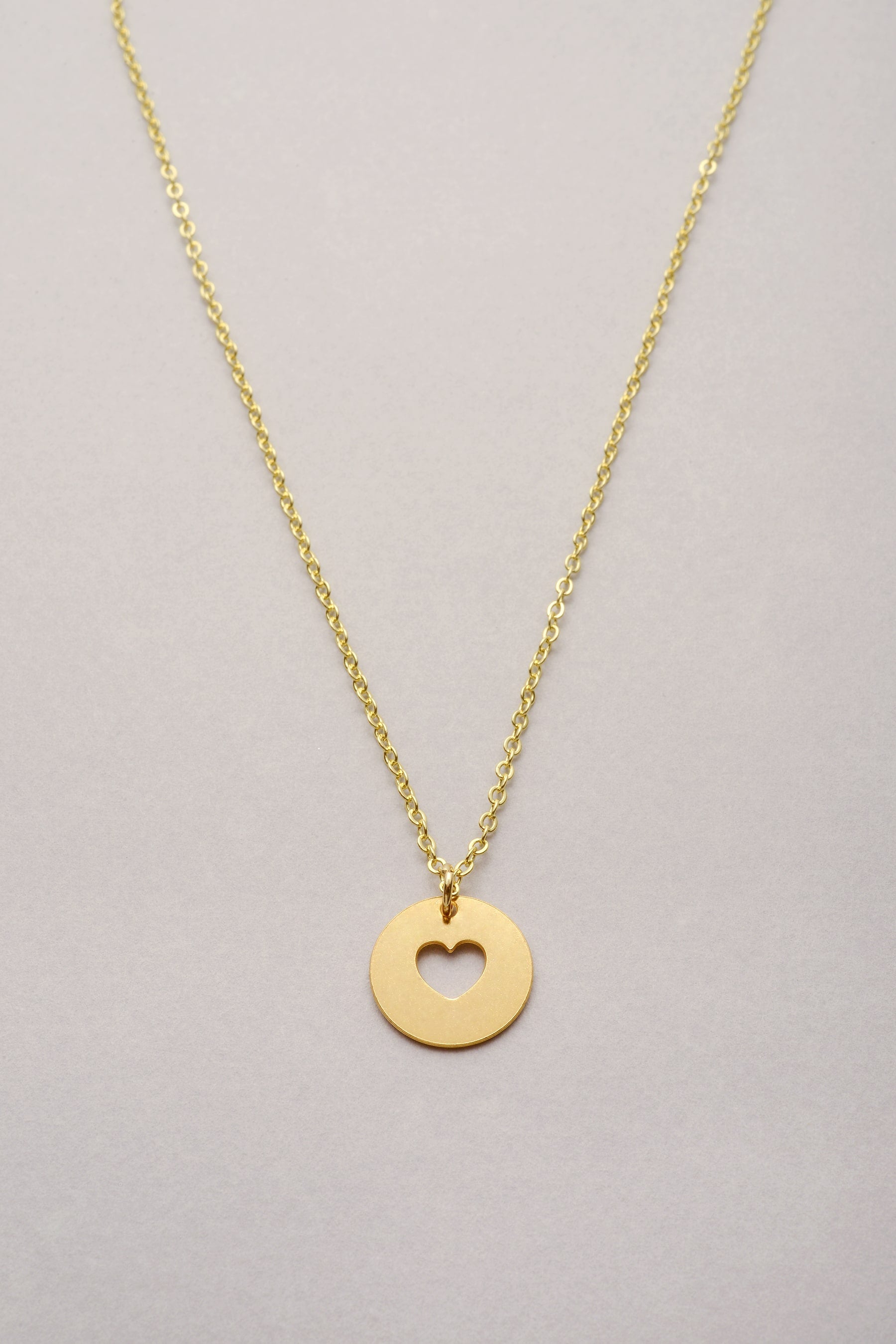 Le collier chaîne avec médaille évidée coeur dorée et son fermoir mousqueton.