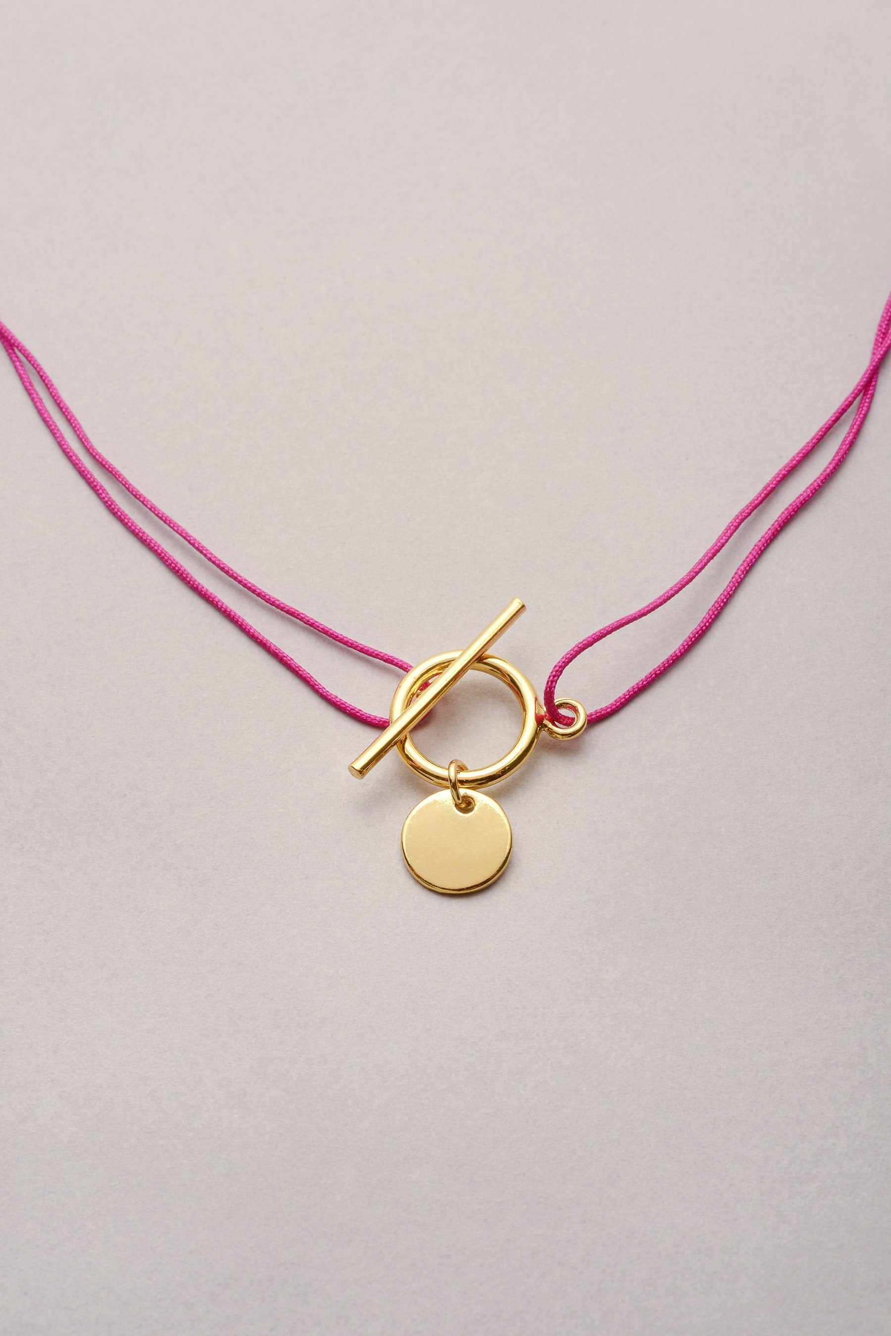 Le collier doré en cordon fil fin coloré de Musardise avec son fermoir fin en T, disponible en argenté et avec d'autres pampilles. Cordon réglable et personnalisable