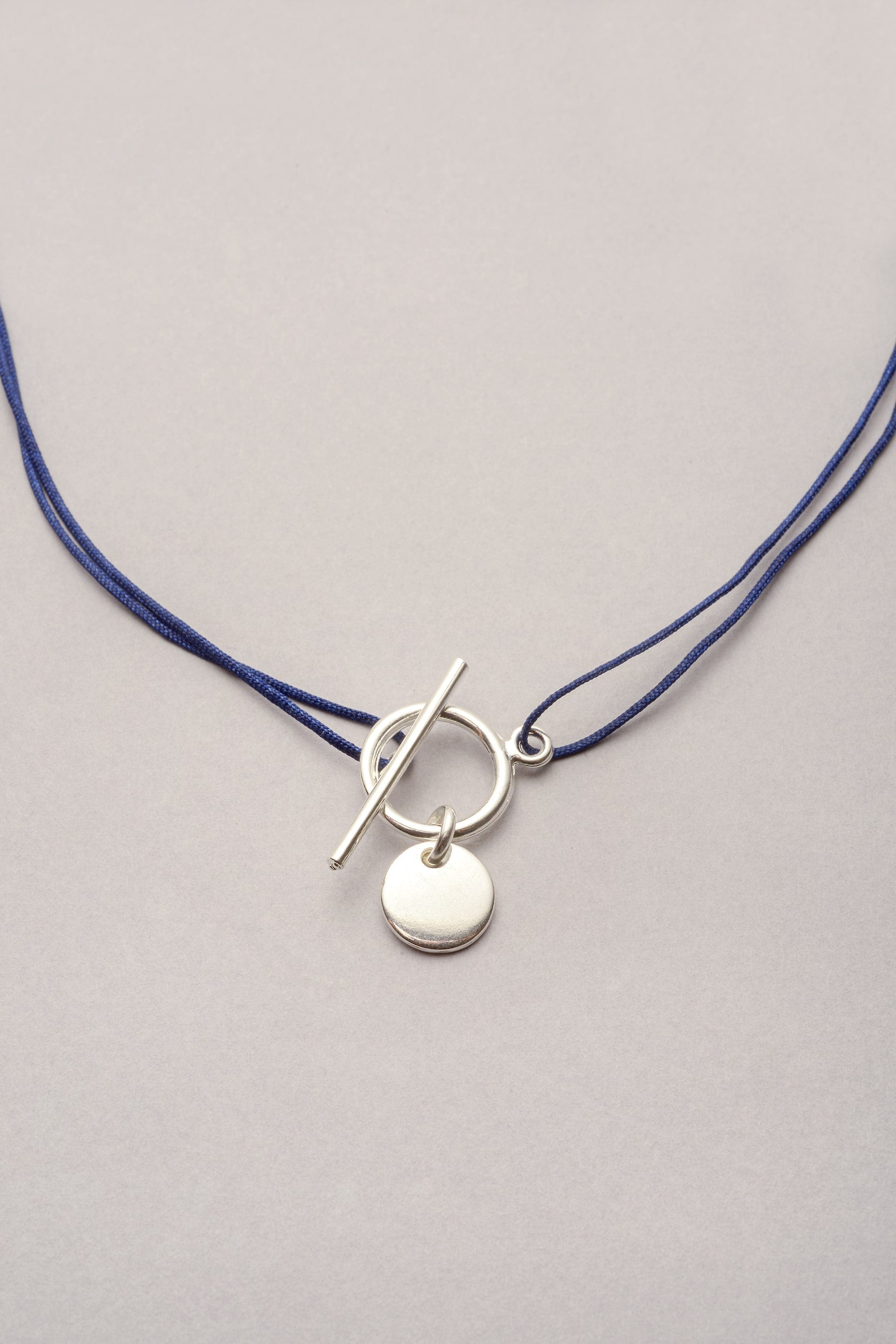 Le collier argenté en cordon fil fin coloré de Musardise avec son fermoir fin en T, disponible en doré et avec d'autres pampilles. Cordon réglable et personnalisable