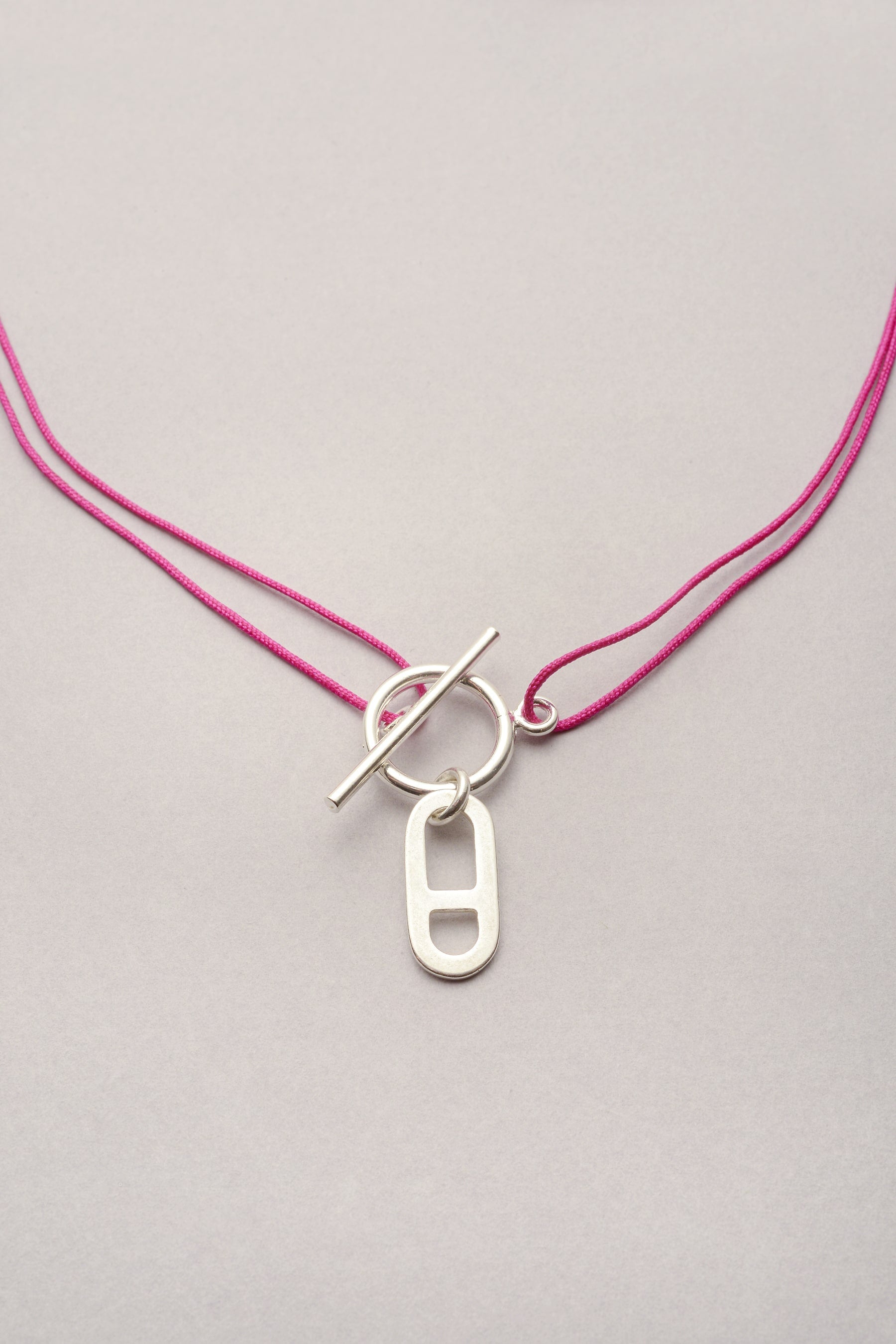 Le collier Musardise avec son cordon fin personnalisable et réglable grâce à ses noeuds coulissants. Son attache avec son fermoir facile en forme de T permet d'attacher le collier en ras de cou ou plus long