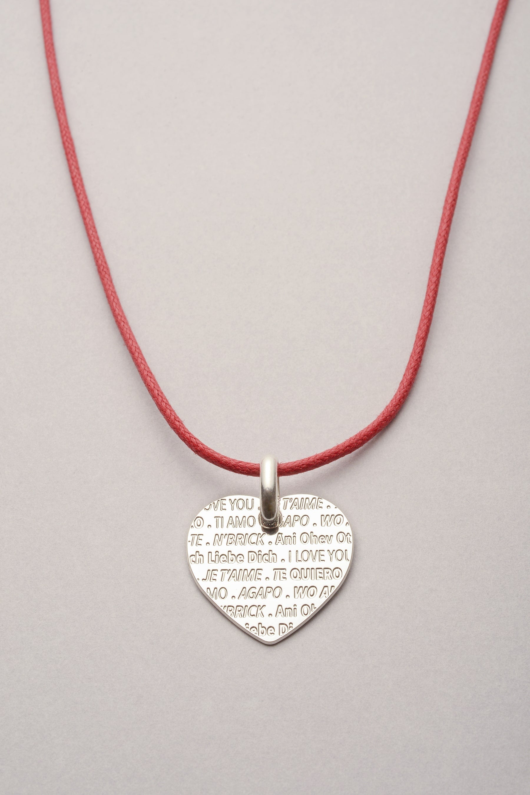 Ce collier est composé d'un pendentif coeur je t'aime avec la phrase "je t'aime" gravée en plusieurs langues. En plus, ce bijou est réglable grâce à son cordon aux noeuds coulissants. 