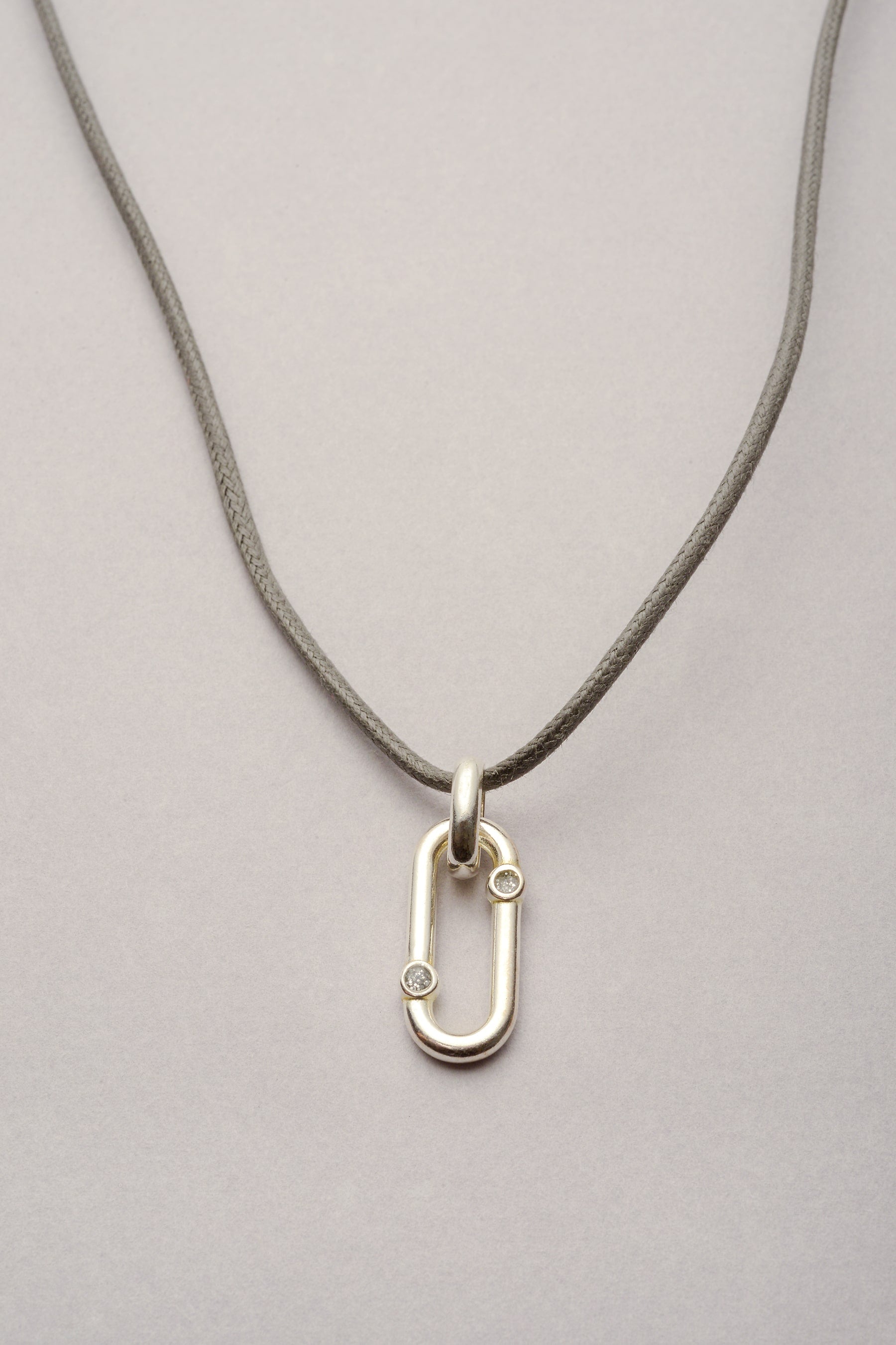 Ce collier est composé d'un pendentif oval avec deux stras en résine pailletés. ce pendentif est posé sur un cordon de coton coloré, réglable et personnalisable dans la couleur de votre choix ! 