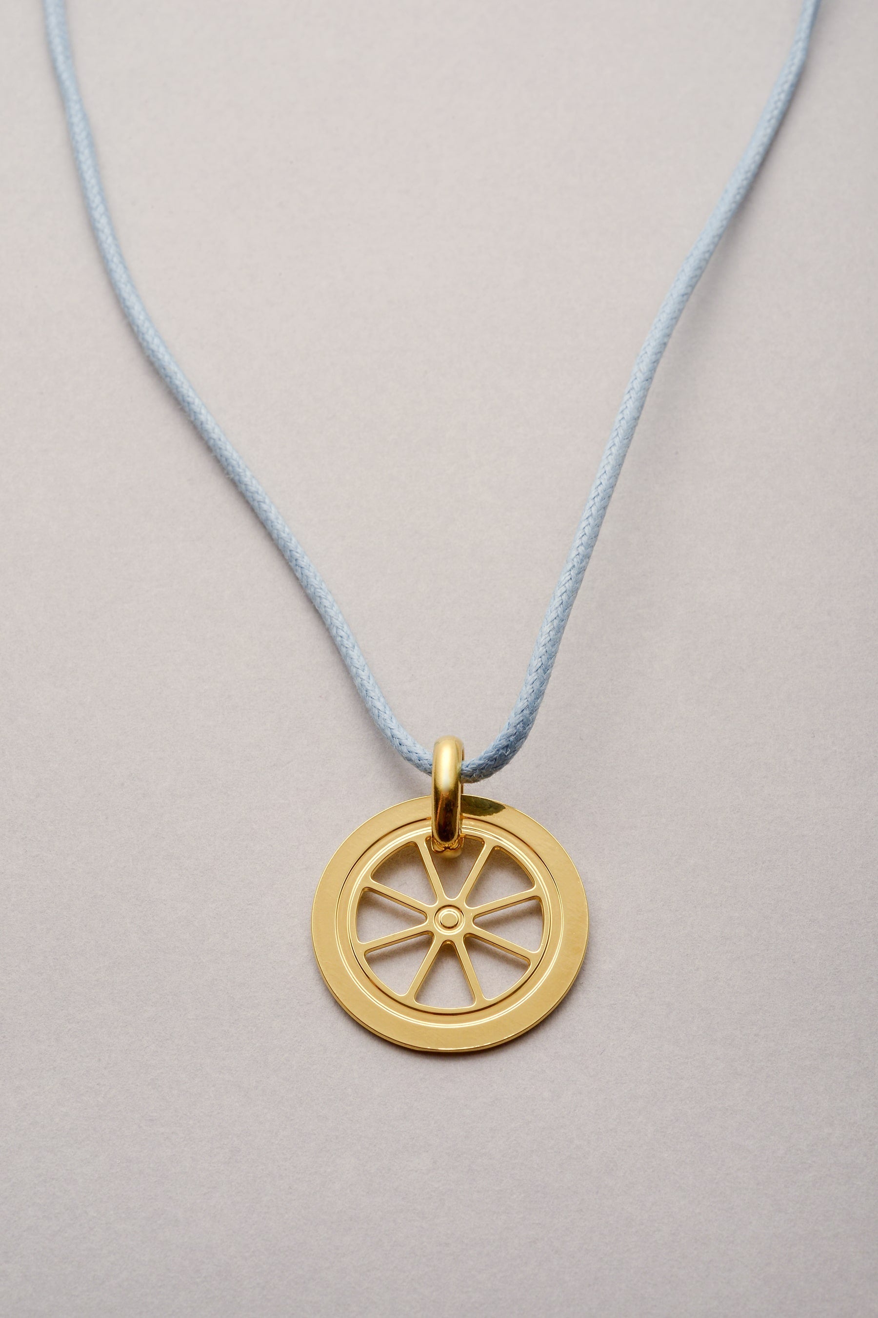 Ce collier est composé d'un cordon et d'un pendentif en forme de roue de 26mm doré. Réglable, la longueur s'ajuste grâce à ses deux noeuds coulissants. Ce bijou est fabriqué en France, et assemblé dans notre atelier à toulouse. 