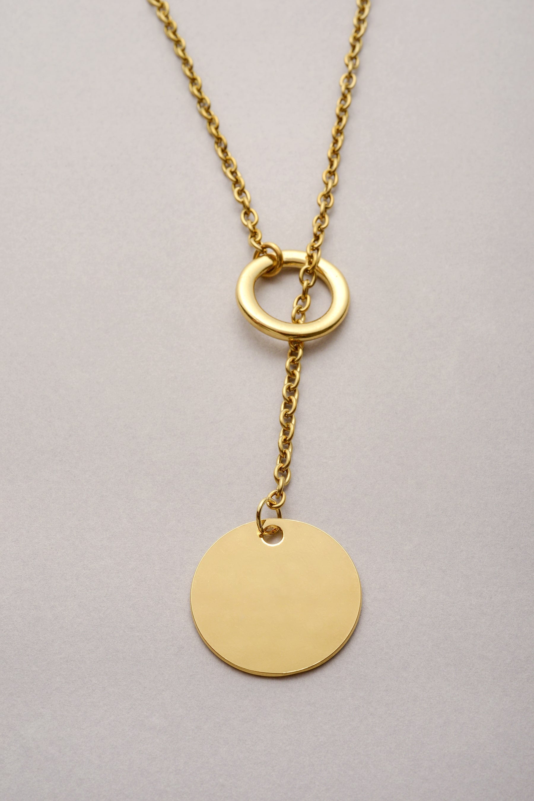 Collier sautoir doré Daya avec pendentif médaille ronde lisse, bijou fantaisie moderne de chez Musardise et fabriqué en France.