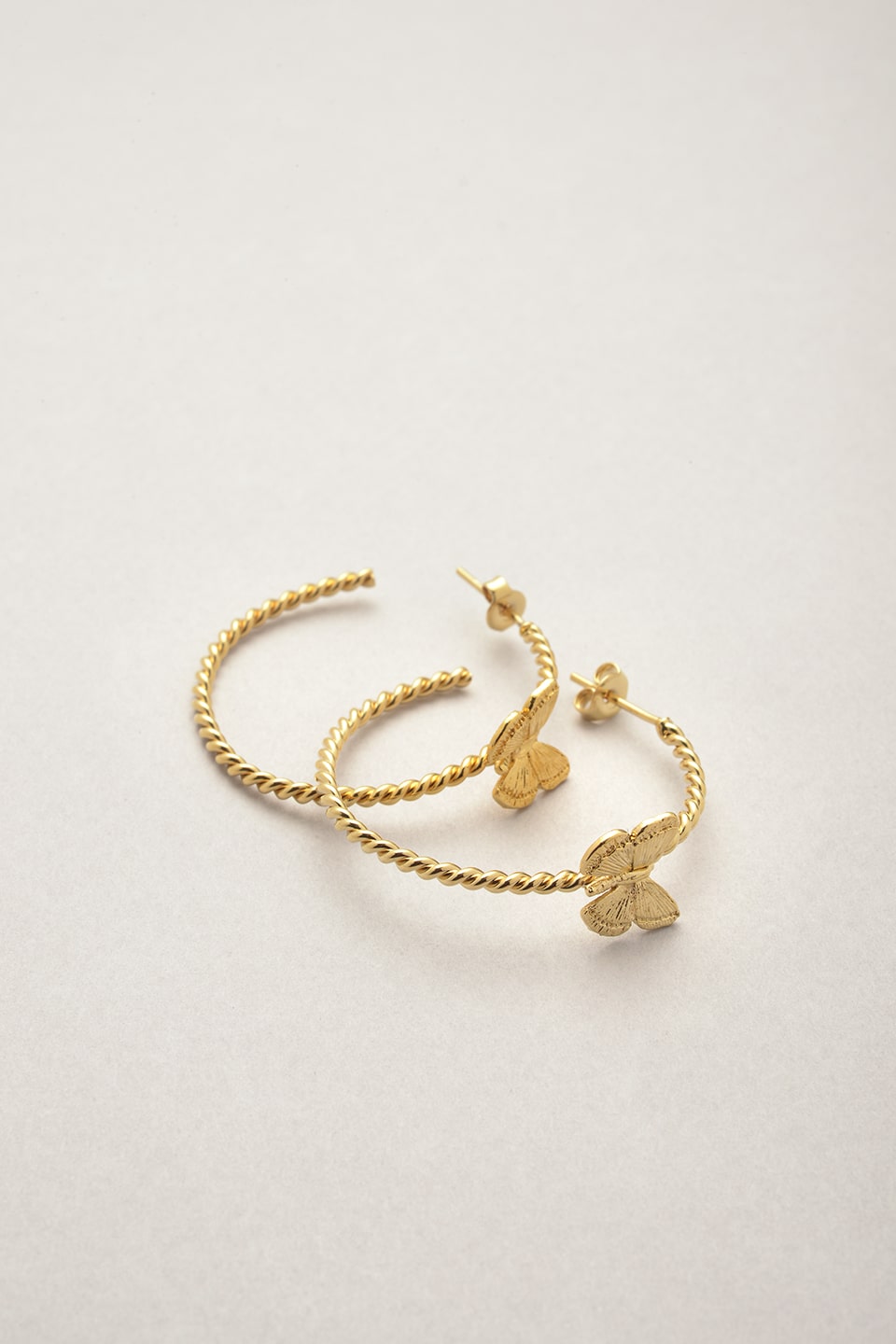 Les créoles dorées torsadées avec un détail papillons doré de Musardise