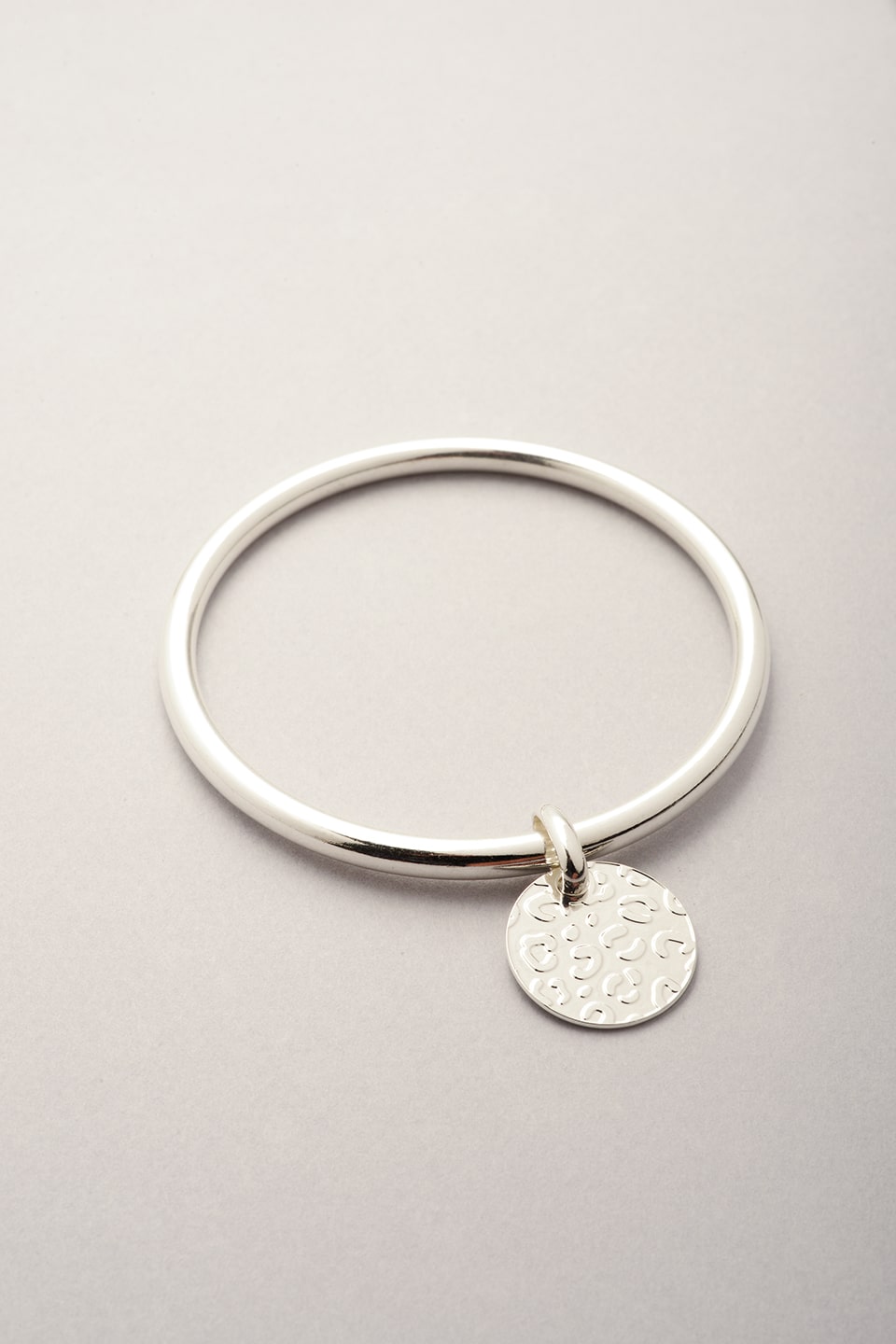 Ce bijou est composé d'un bracelet jonc argenté et d'une médaille avec des reliefs léopard. Bijou argenté pour femme fabriqué en France. 