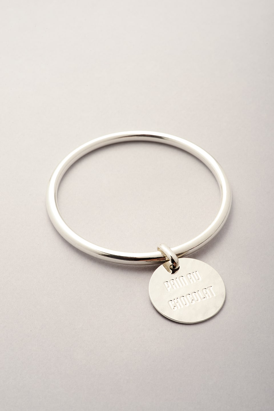 Jonc argenté avec médaille sur laquelle est gravé Pain au chocolat. Bijou fabriqué en France pour femme. 