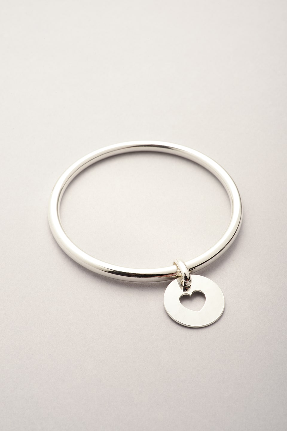 Ce jonc argenté se compose d'une médaille avec un coeur évidé. Jonc argenté pour femme fabriqué en France. 