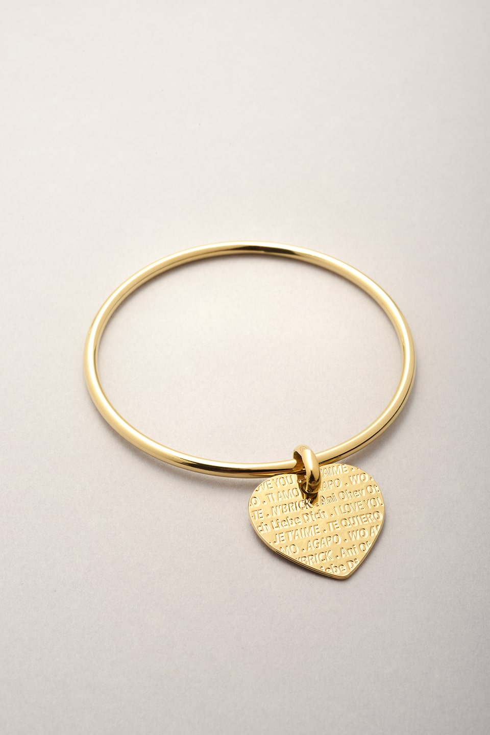 Ce bracelet est composé d'un jonc doré et d'un pendentif en forme de coeur. Sur le pendentif est inscrit la phrase je t'aime en plusieurs langues. Inspiré du mur des je t'aime à Paris. Création Musardise France. 
