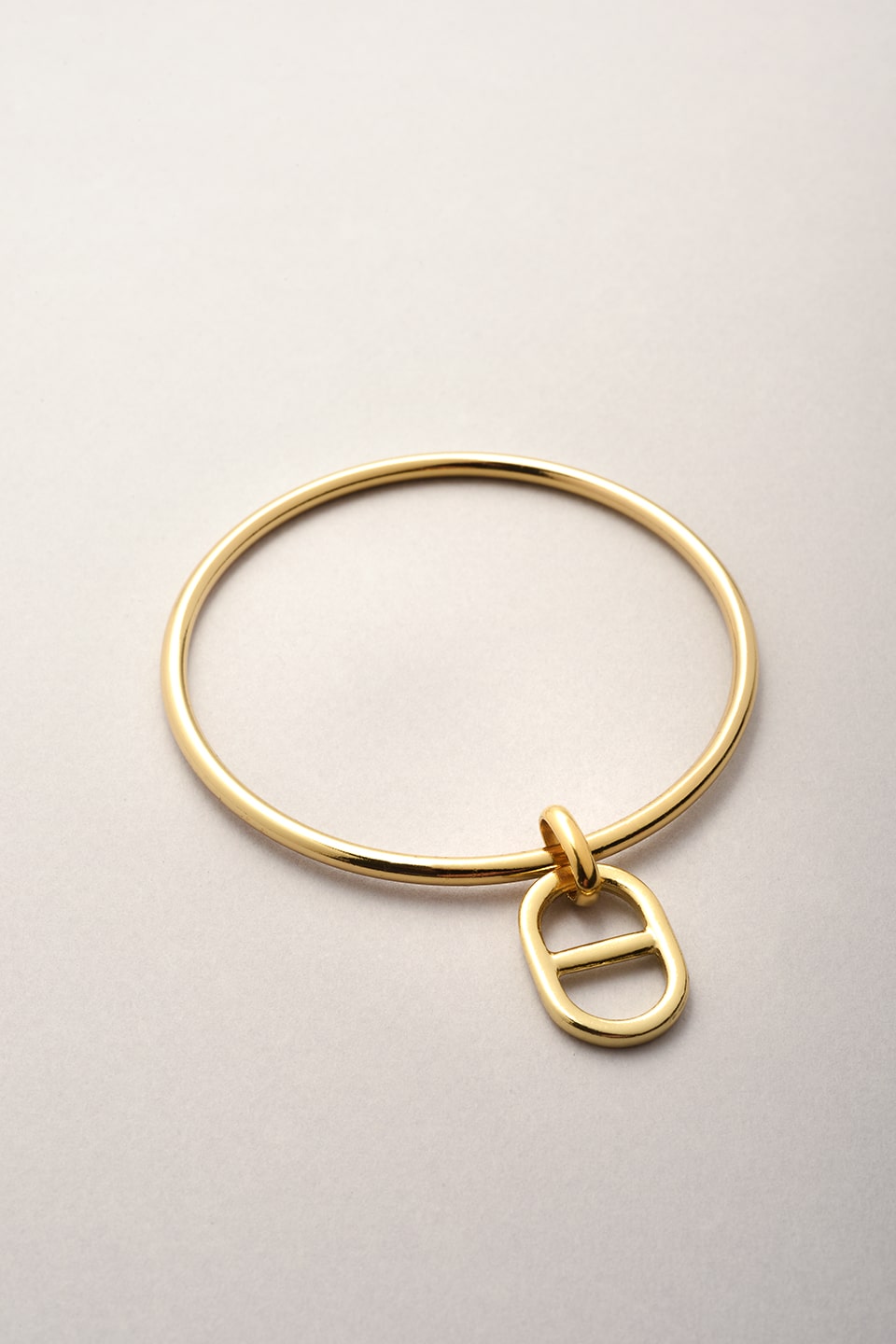 Jonc doré avec pendentif maille. Ce bijou fantaisie fabriqué en France existe en plusieurs coloris. 