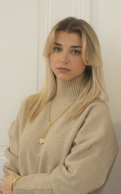 Sautoir doré avec pendentif cœur texturé motif léopard, monté sur une chaîne dorée.