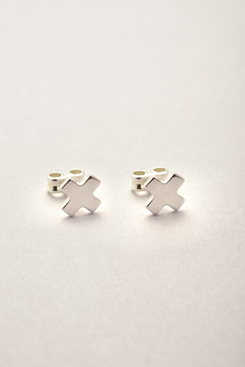 Les puces d'oreilles argentées de Musardise en forme de croix appelées "cruz" disponible dans la catégorie boucles d'oreilles