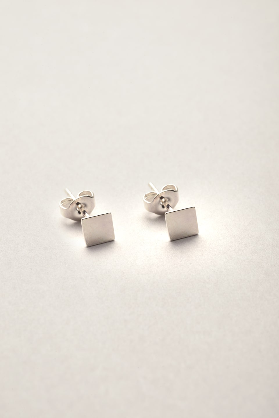 Les puces d'oreilles argentées Musardise en forme de carreaux