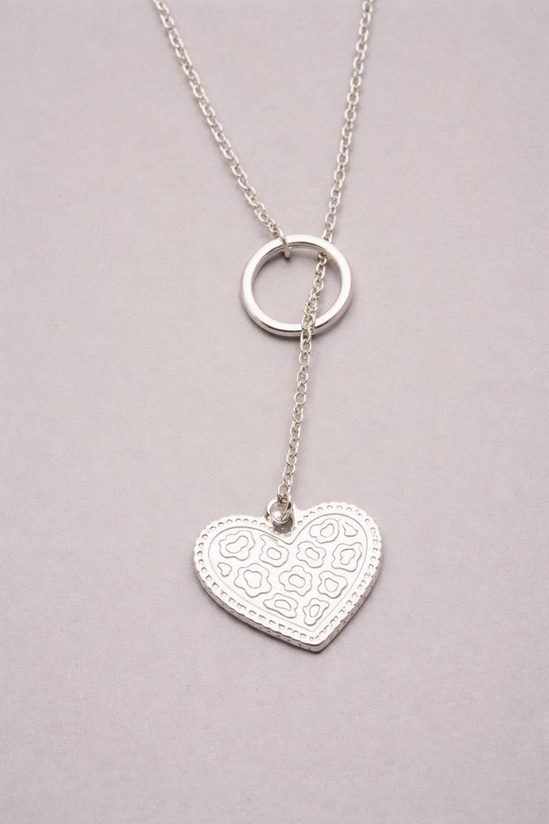 Sautoir argenté avec pendentif cœur texturé motif léopard, monté sur une chaîne argentée.