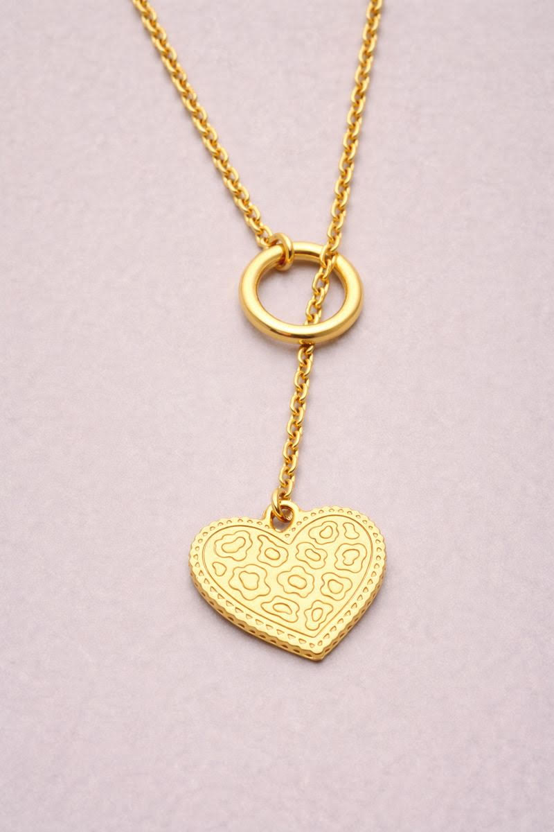 Sautoir doré avec pendentif cœur texturé motif léopard, monté sur une chaîne dorée.