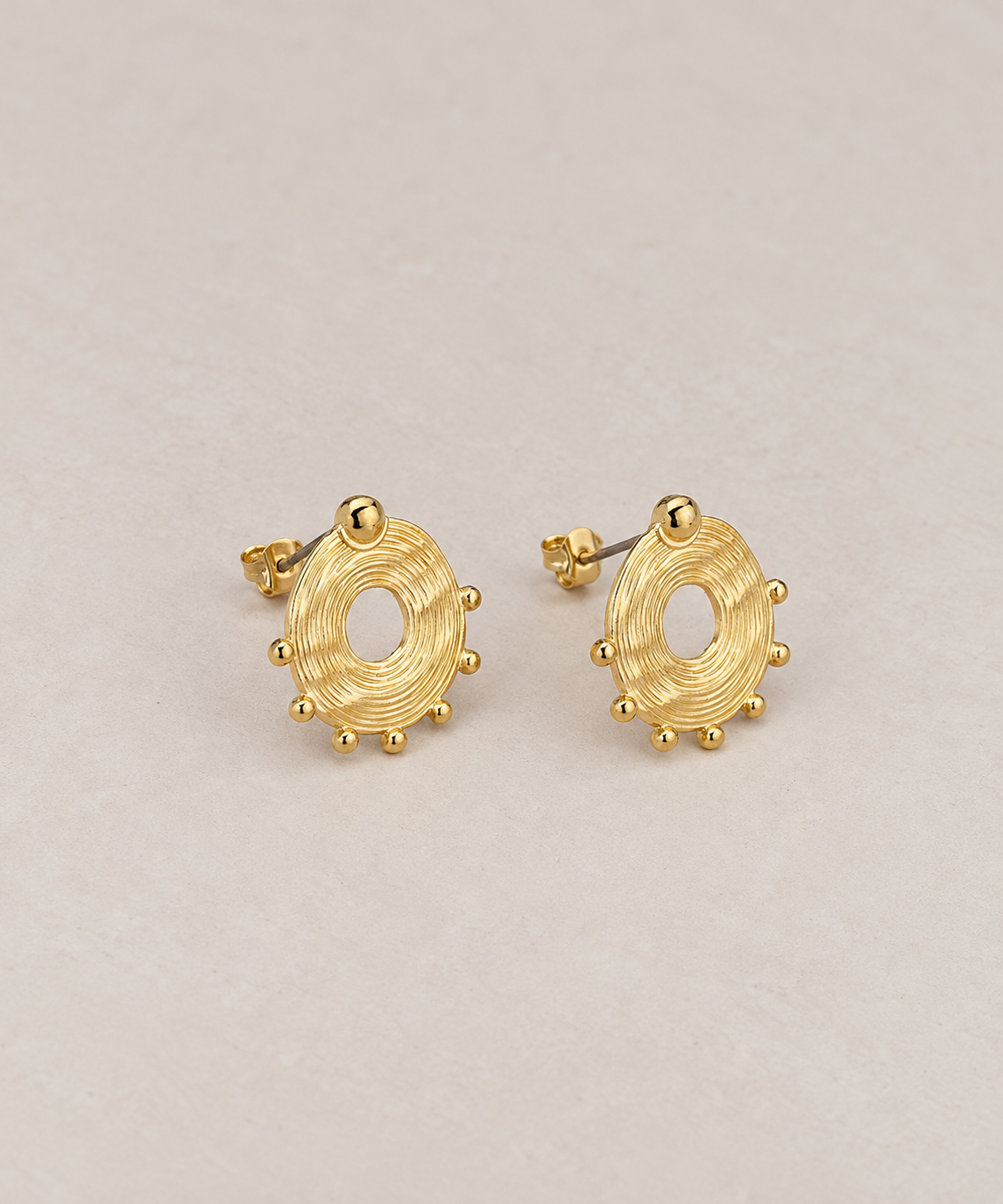Boucles d’oreilles Soléa dorées – paire sur fond beige Musardise