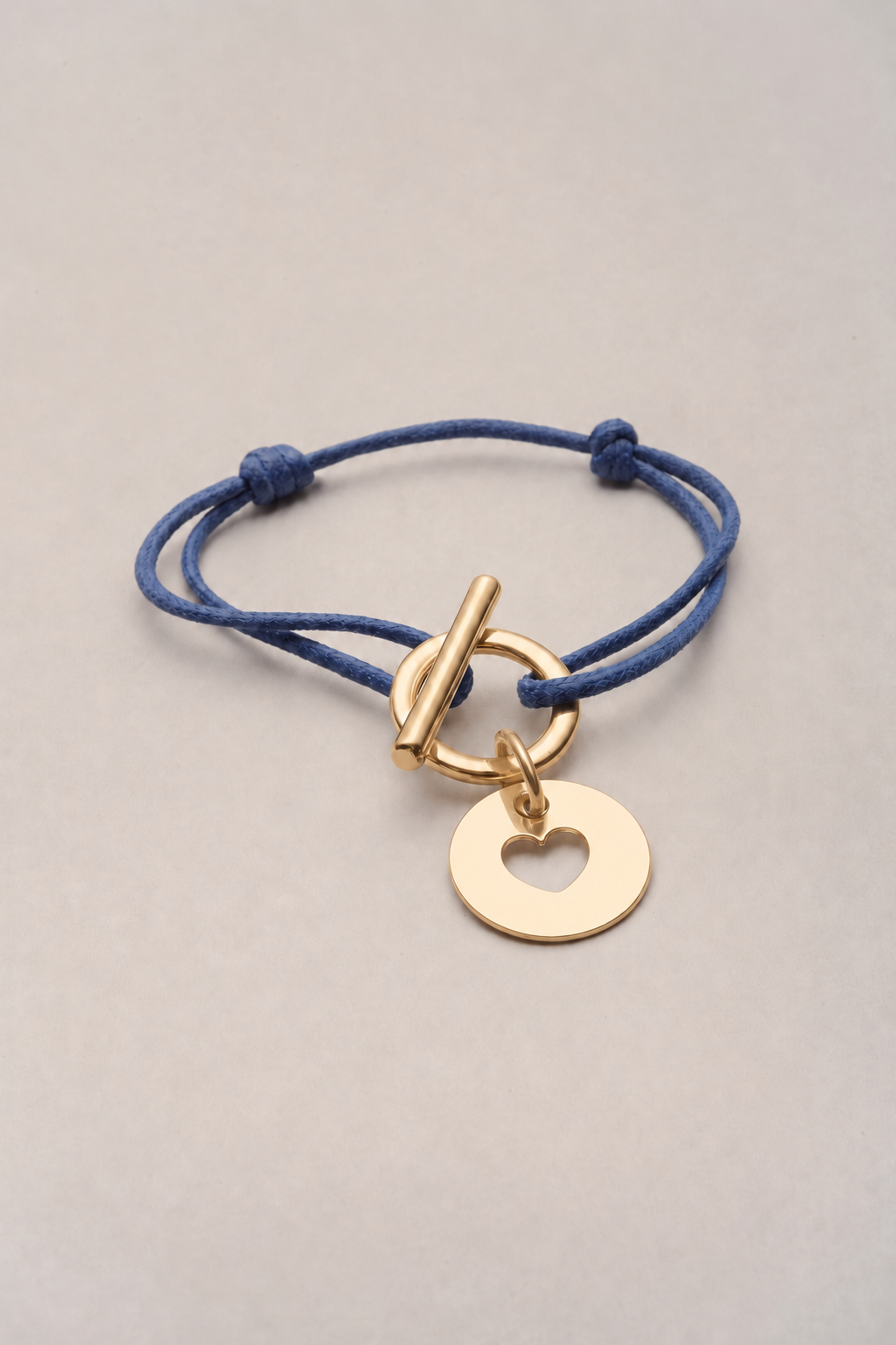 Bracelet attache cœur doré, cordon bleu et médaille cœur ajouré