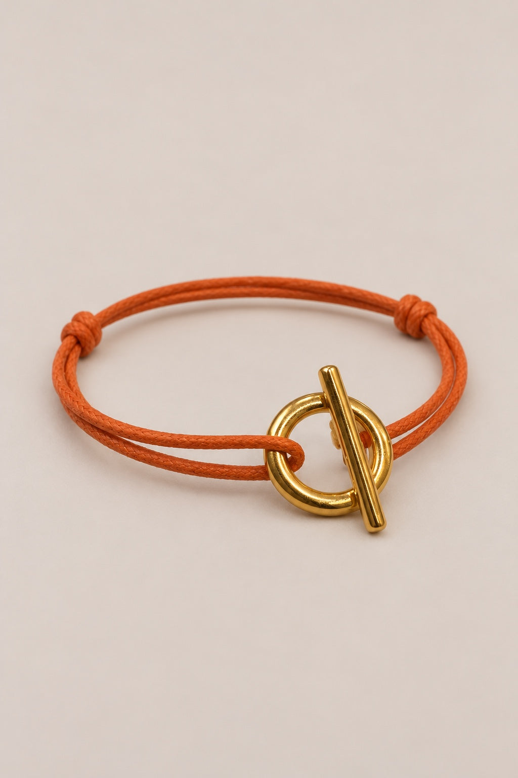 Bracelet fermoir T doré avec cordon orange
