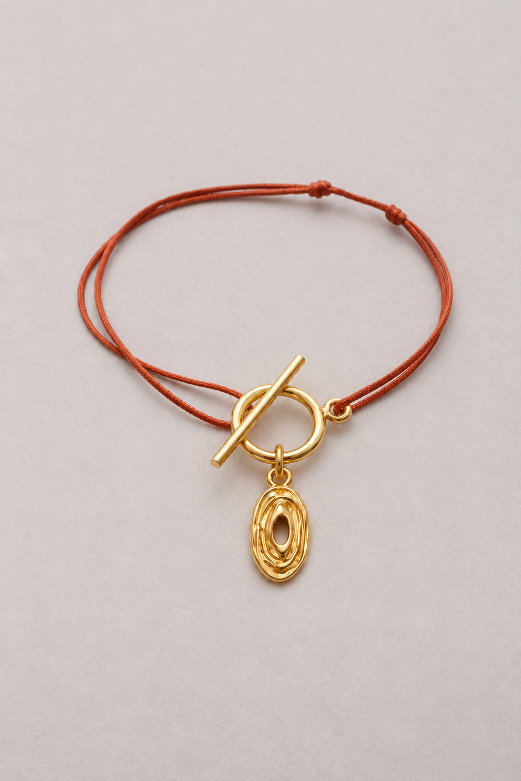 Bracelet Lou Hazel doré, cordon terracotta et pendentif ovale ajouré