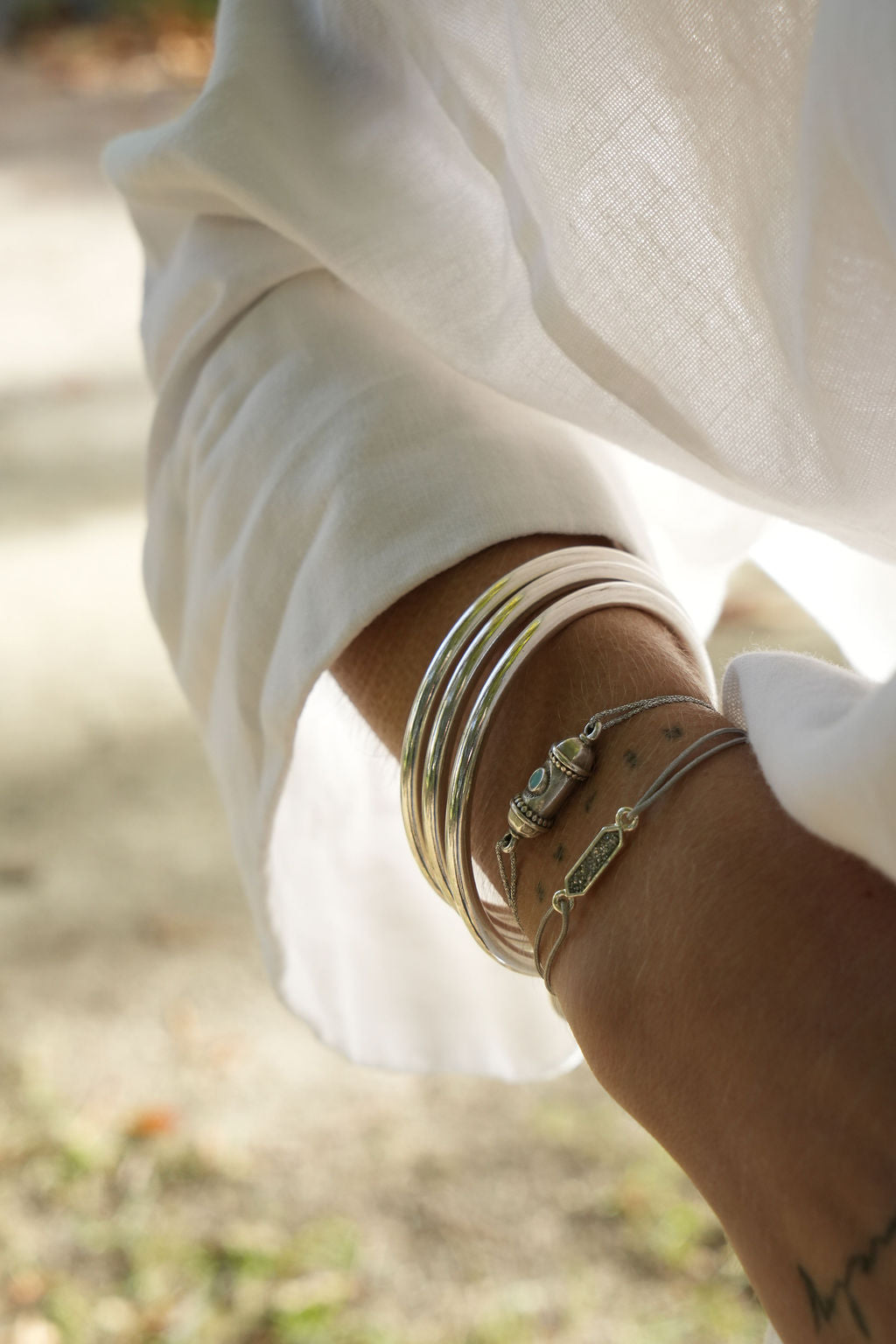 Bracelet strass argenté porté avec des joncs argentés