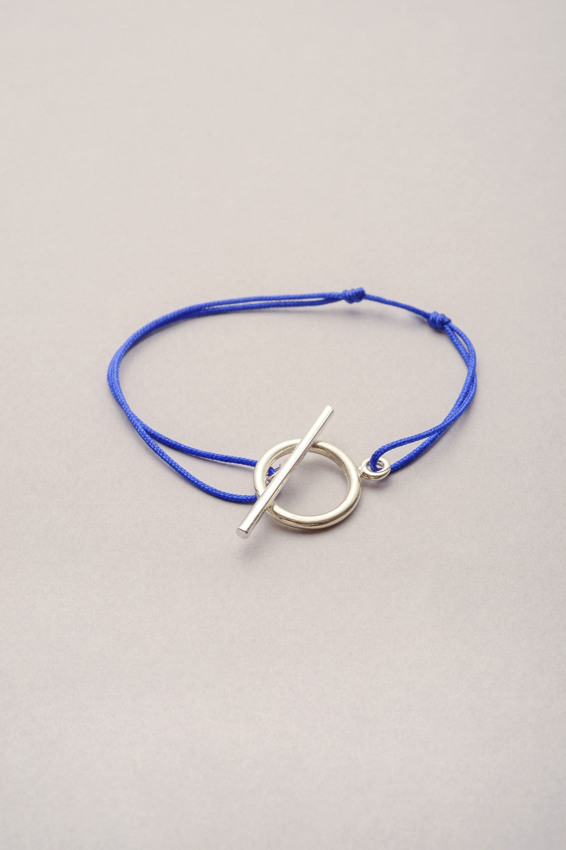 Le bracelet Lou, un bracelet argenté sur fil fin coloré disponible en plusieurs coloris avec son attache argentée en fermoir T