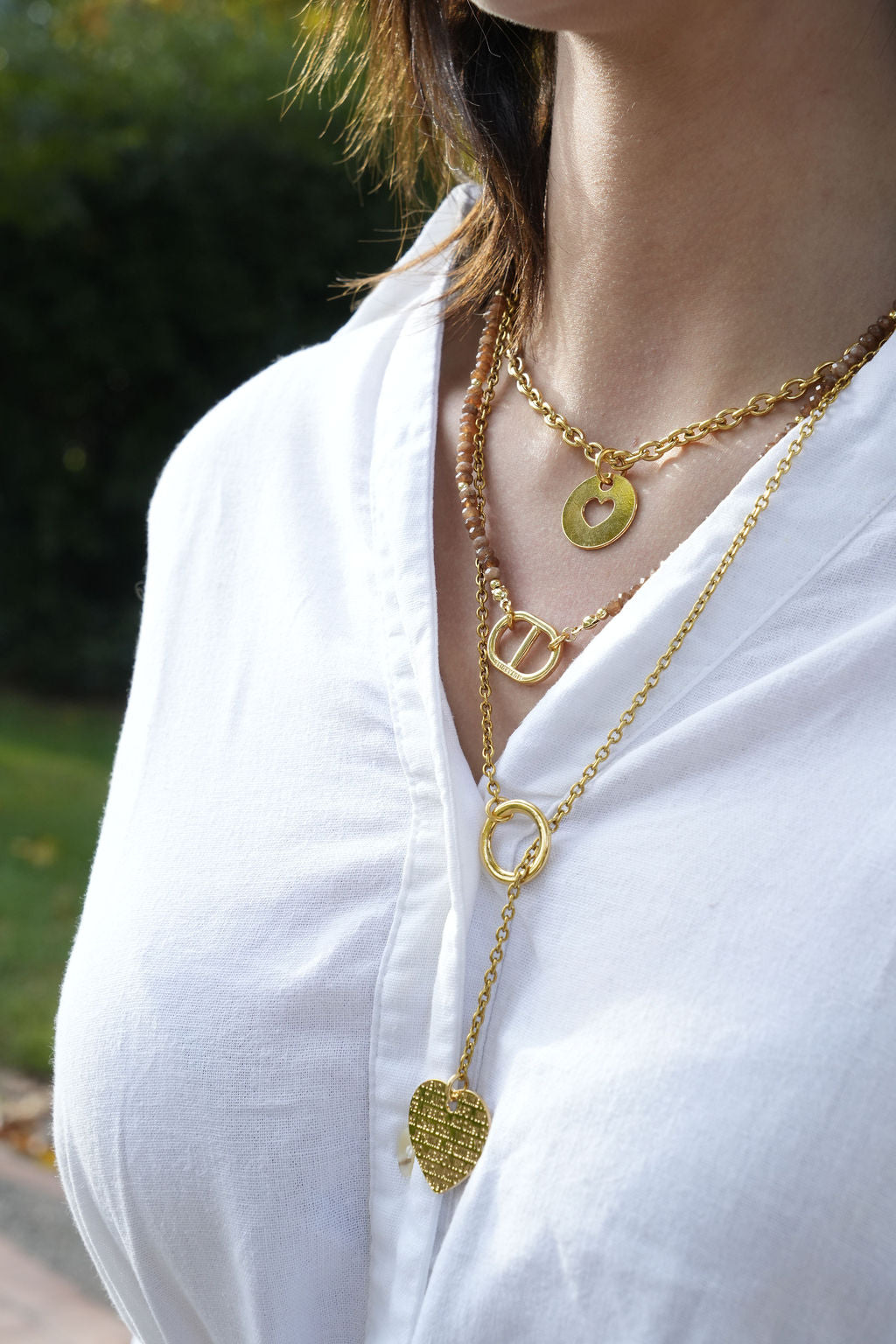Collier maille perles doré porté en accumulation avec d'autres colliers