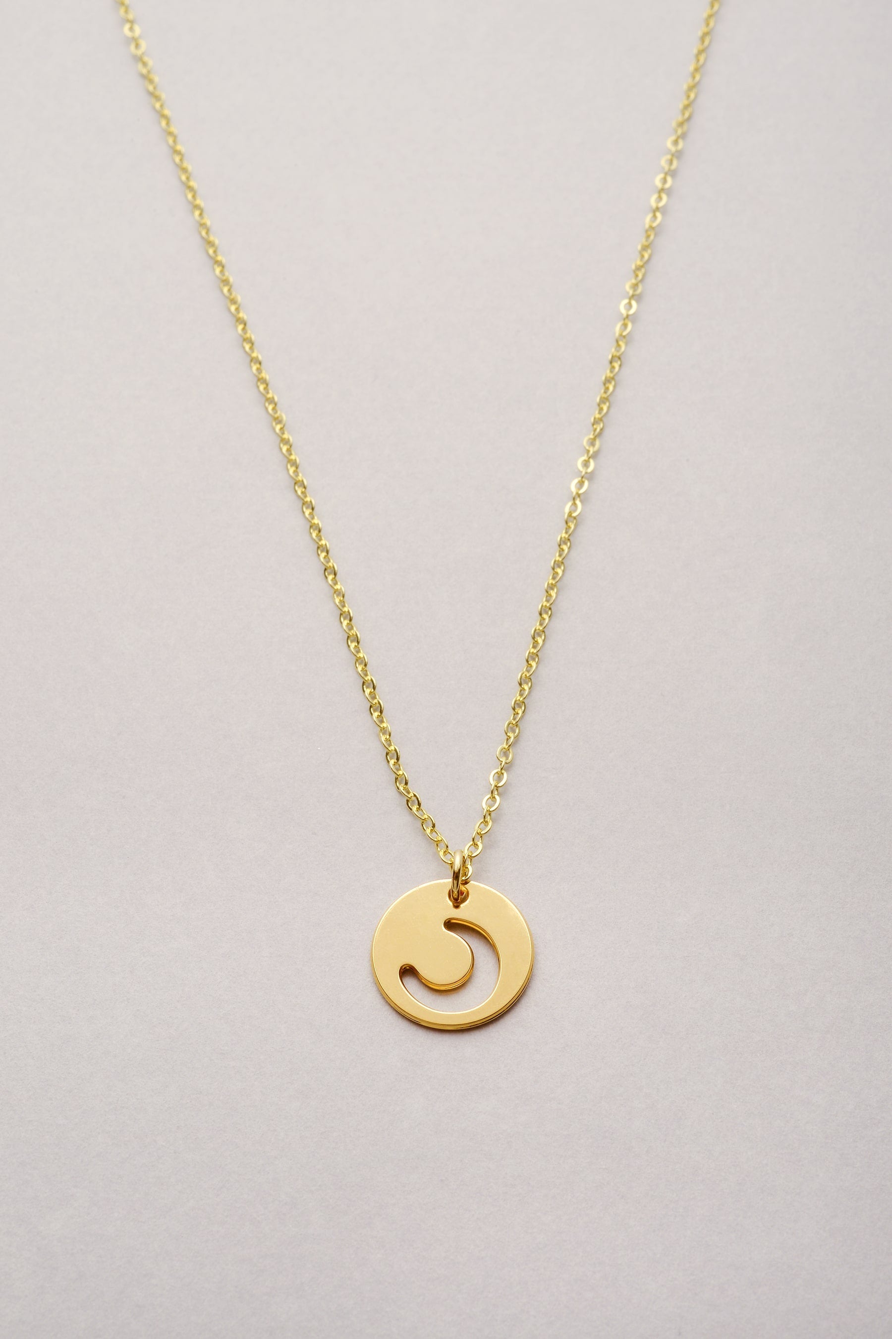 Le collier chaîne fine doré et médaille évidée avec une forme de Lune. Bijou pour femme fabriqué en France. 