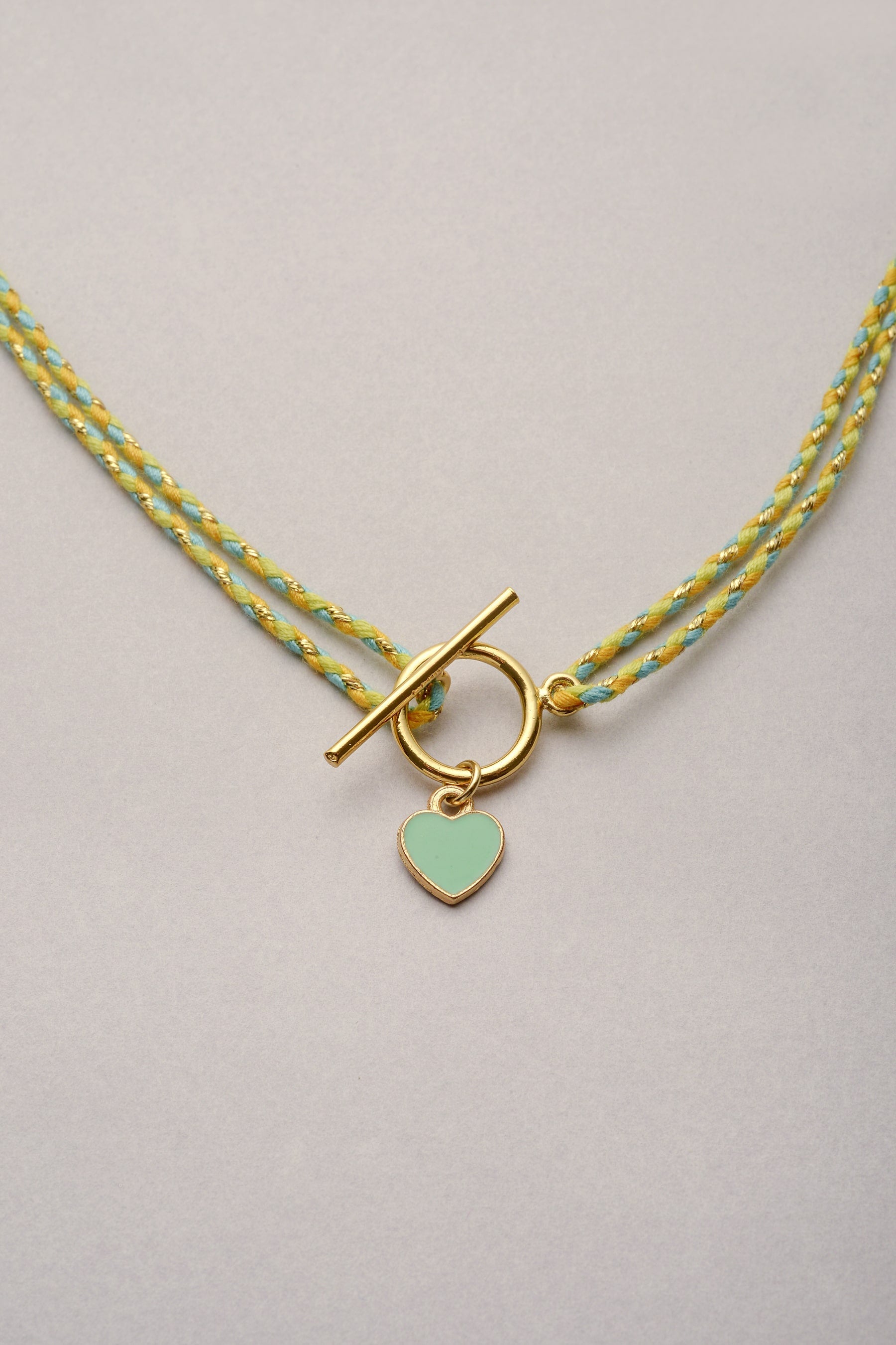 Le collier Lou coeur coloré sur cordon tressé Musardise. Réglable, ajustable et facile à mettre grâce à son fermoir en T.