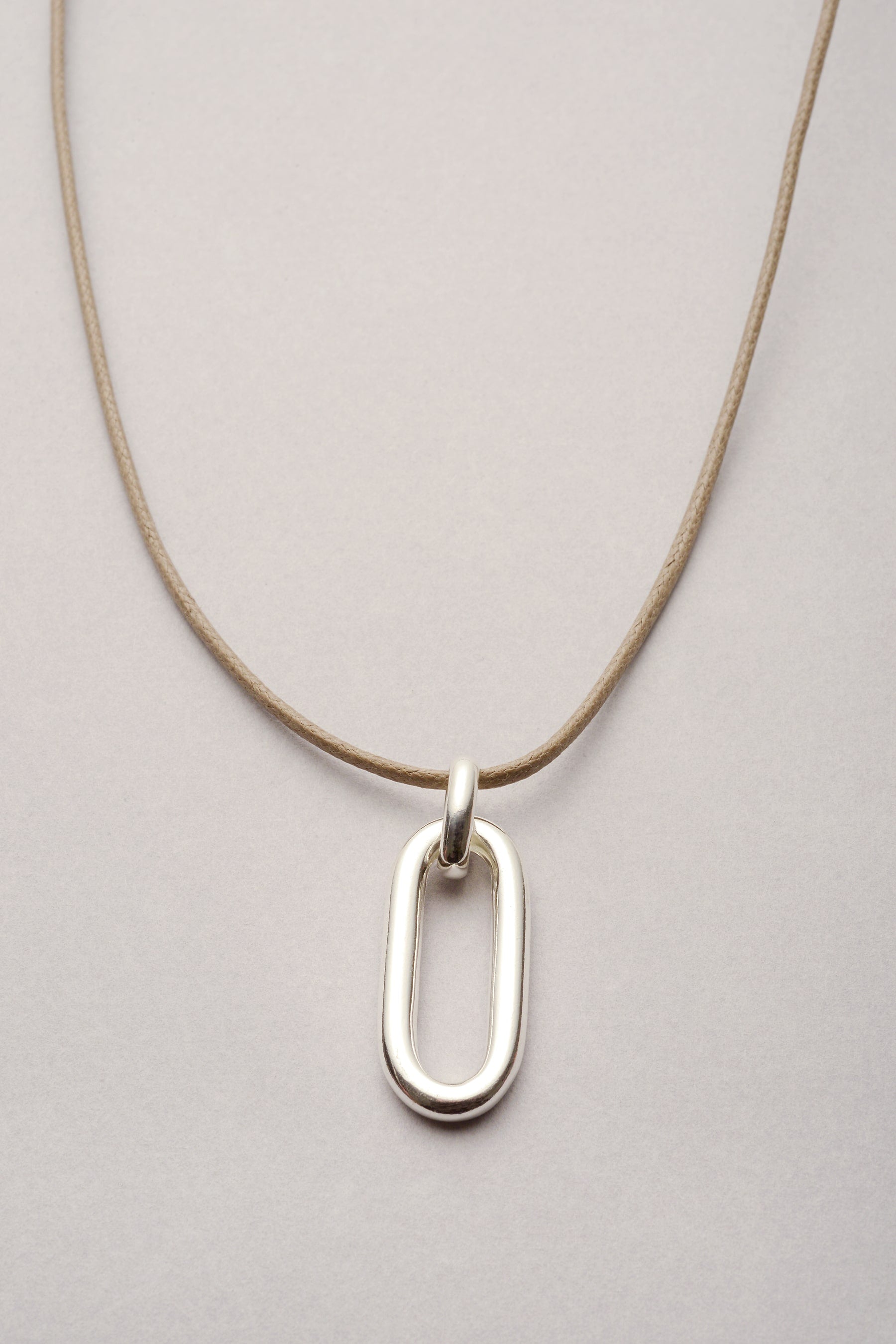 Ce collier se compose d'un pendentif rectangle "Ricky" argenté et d'un cordon de coton coloré et ajustable. 