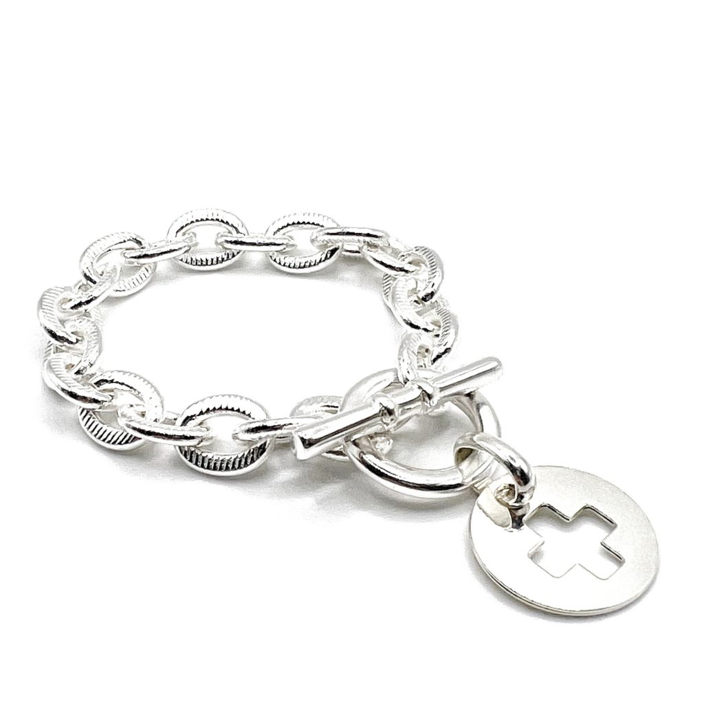 Bracelet scarlett pendentif croix : ce bijou est composé d'une chaîne striée et d'un fermoir en T. On peut personnaliser le bijou avec un pendentif au choix.