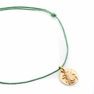 Collier sur cordon vert avec une médaille dorée scarabée