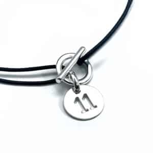 Collier sur cordon noir avec une attache argentée et sa pampille chiffre 11