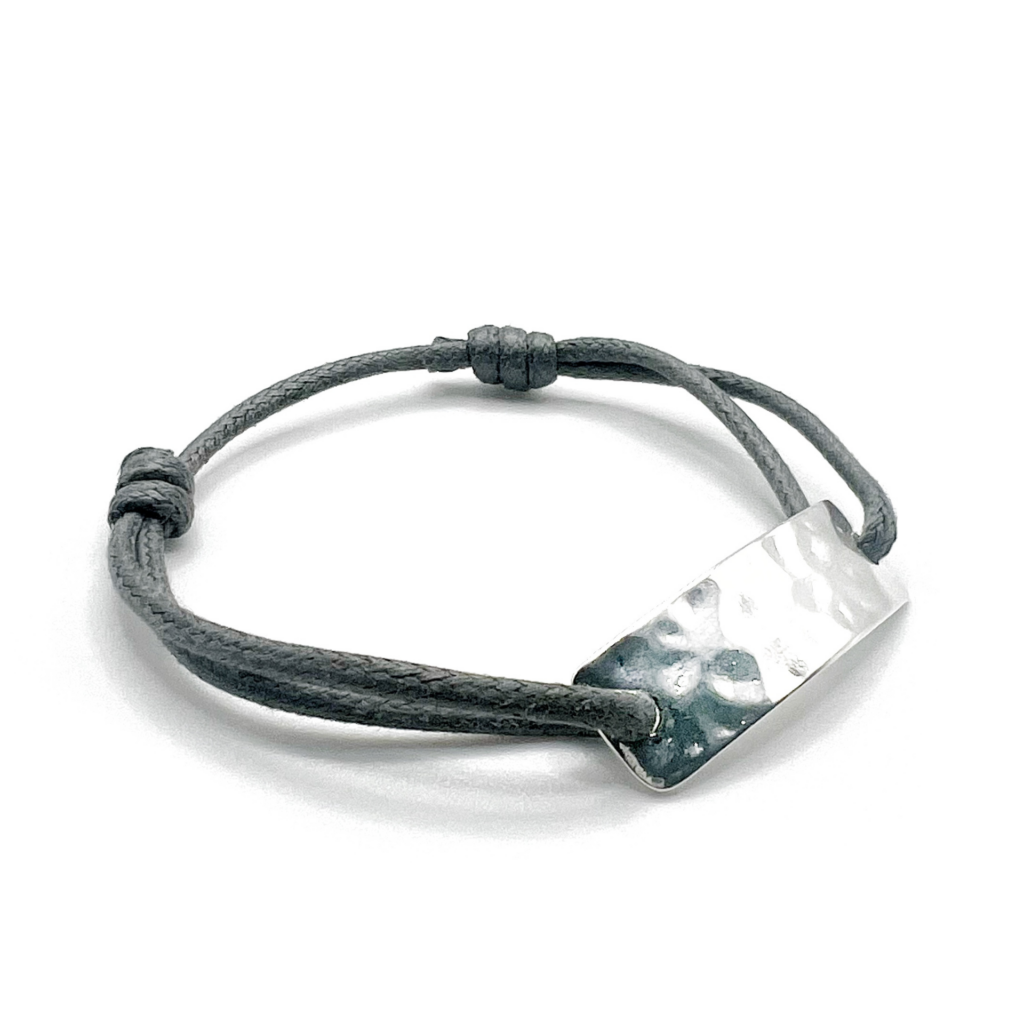 Bracelet argenté avec une plaque martelée et son cordon gris