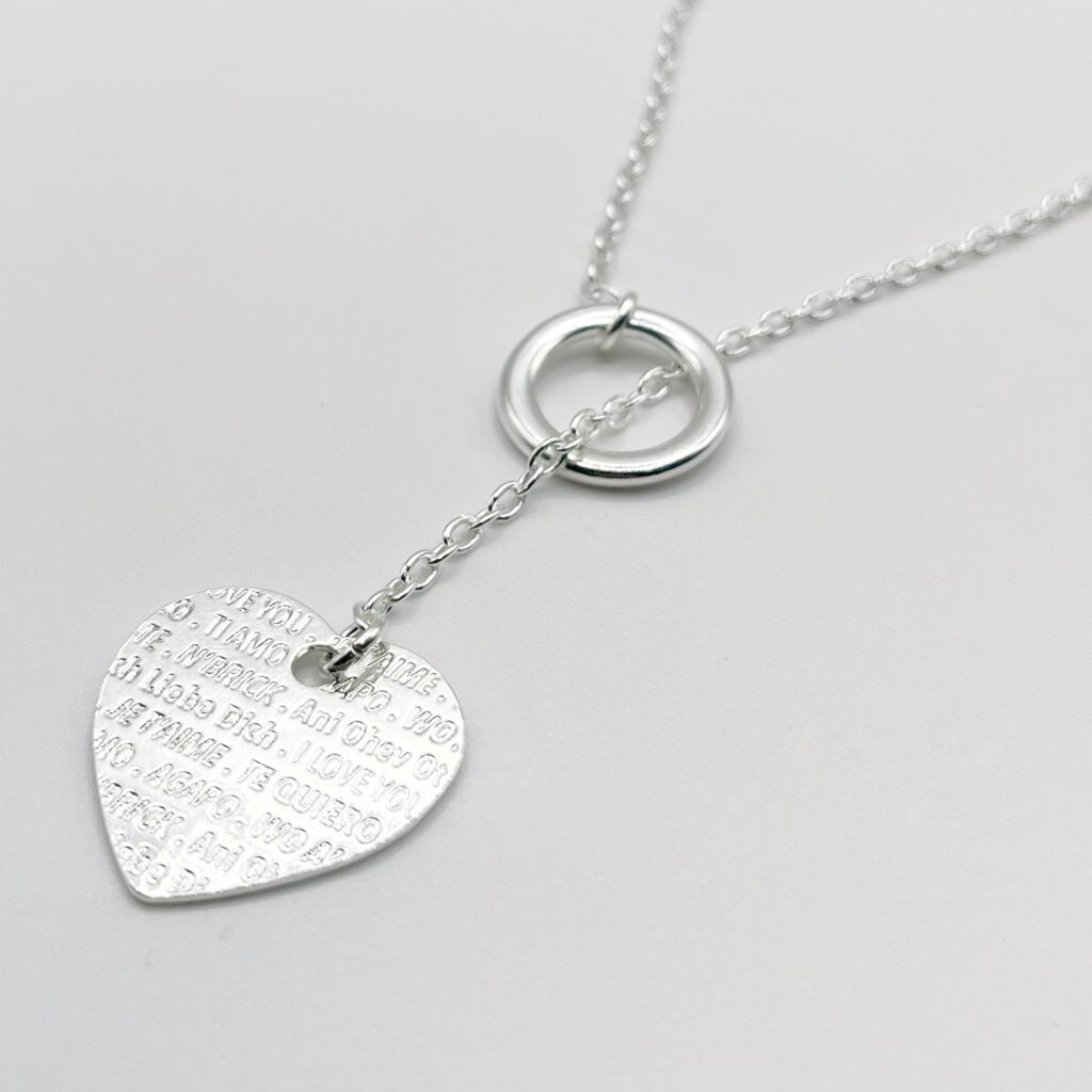 Collier sautoir sur chaîne argentée avec une pampille coeur avec inscriptions "je t'aime"